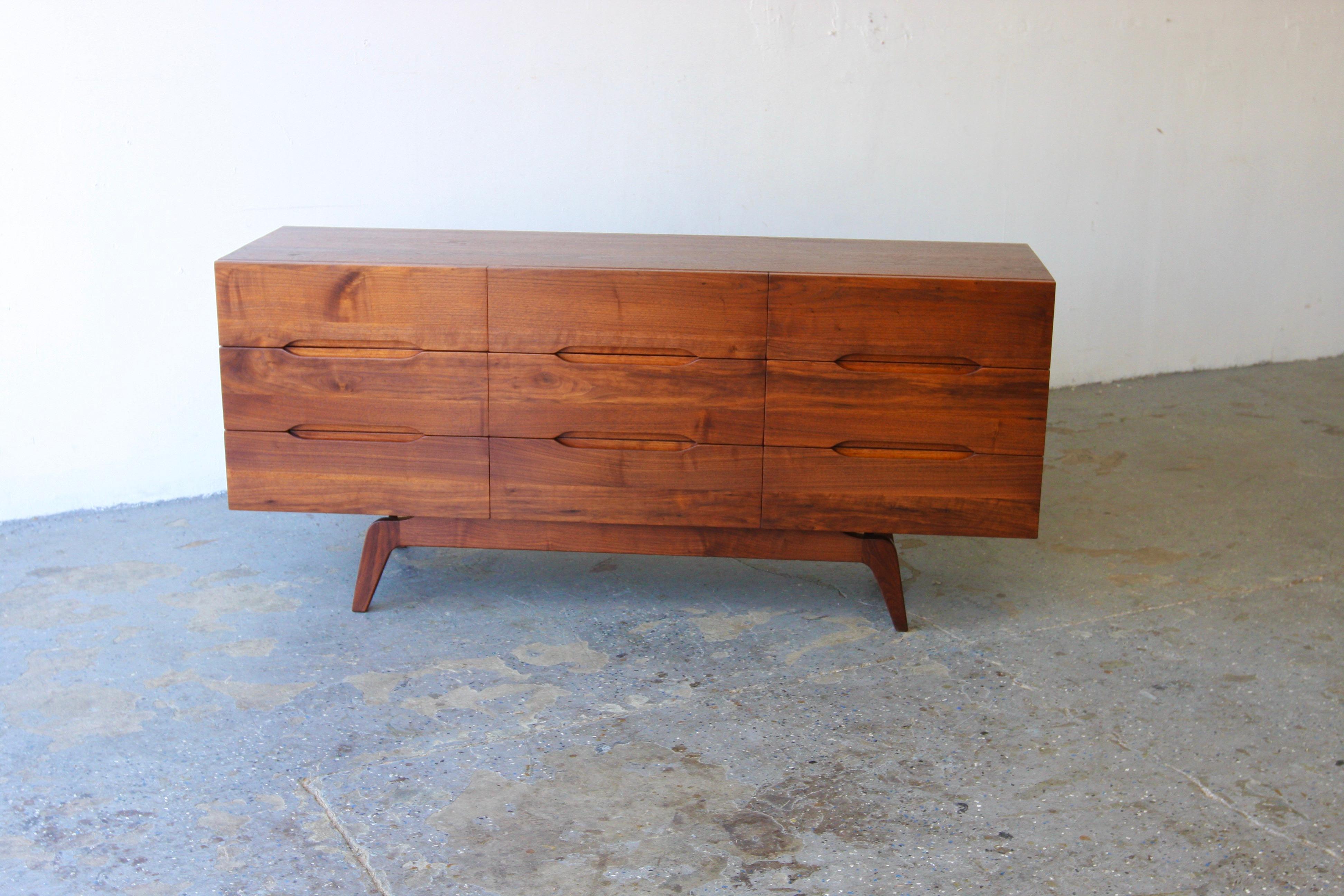 Comò/Credenza in noce massiccio della modernità di metà secolo nello stile di Arne Vodder

Questo comò in noce massiccio, con i suoi squisiti cassetti scolpiti, incarna l'eleganza moderna della metà del secolo. Il design delle gambe strombate