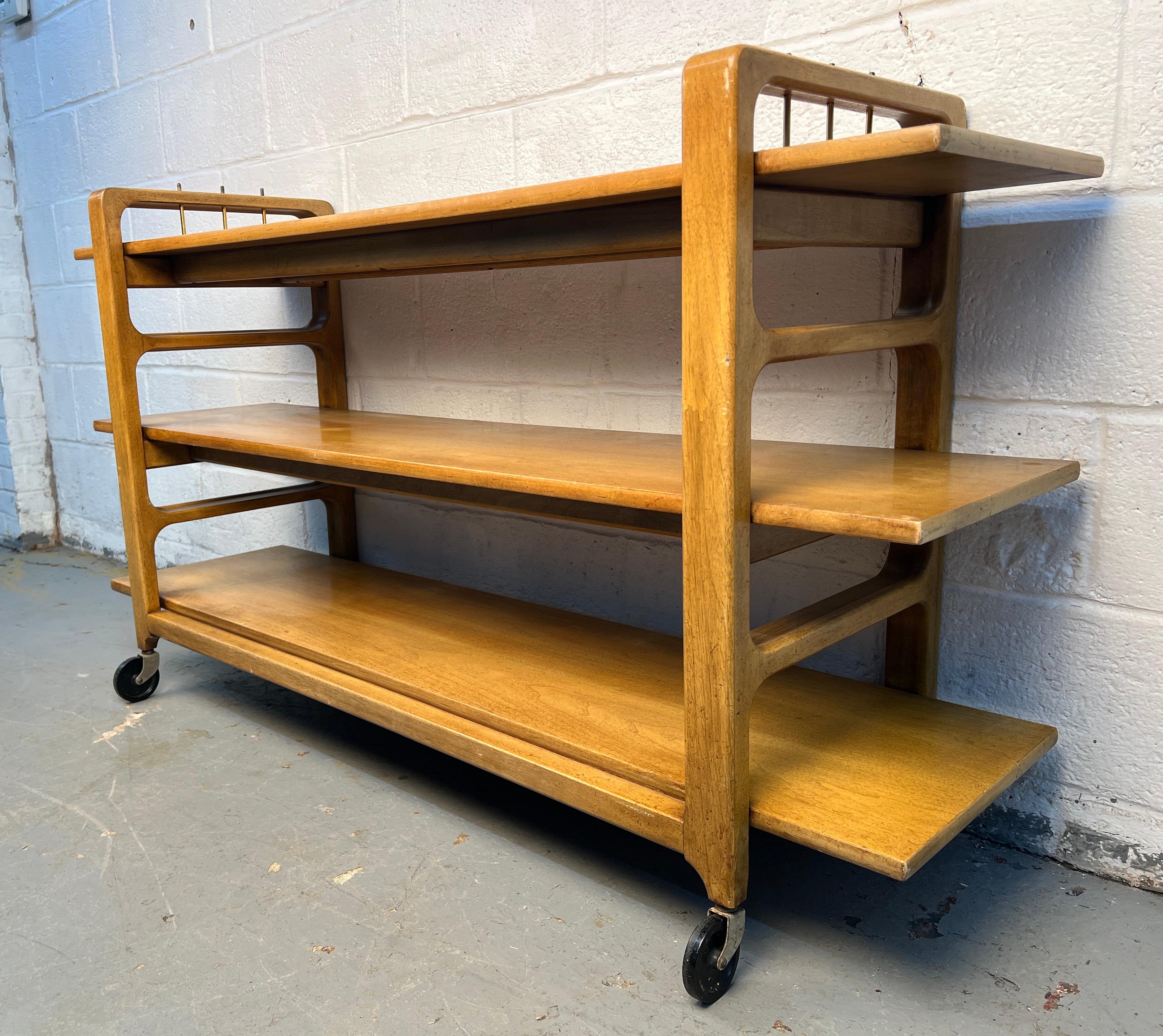 Chariot de bar chic et moderne du milieu du siècle, fabriqué en bois d'érable chaud, au design épuré et minimaliste. Elle est équipée de roues à roulement souple pour une mobilité aisée et d'étagères ouvertes pour le service ou l'exposition,