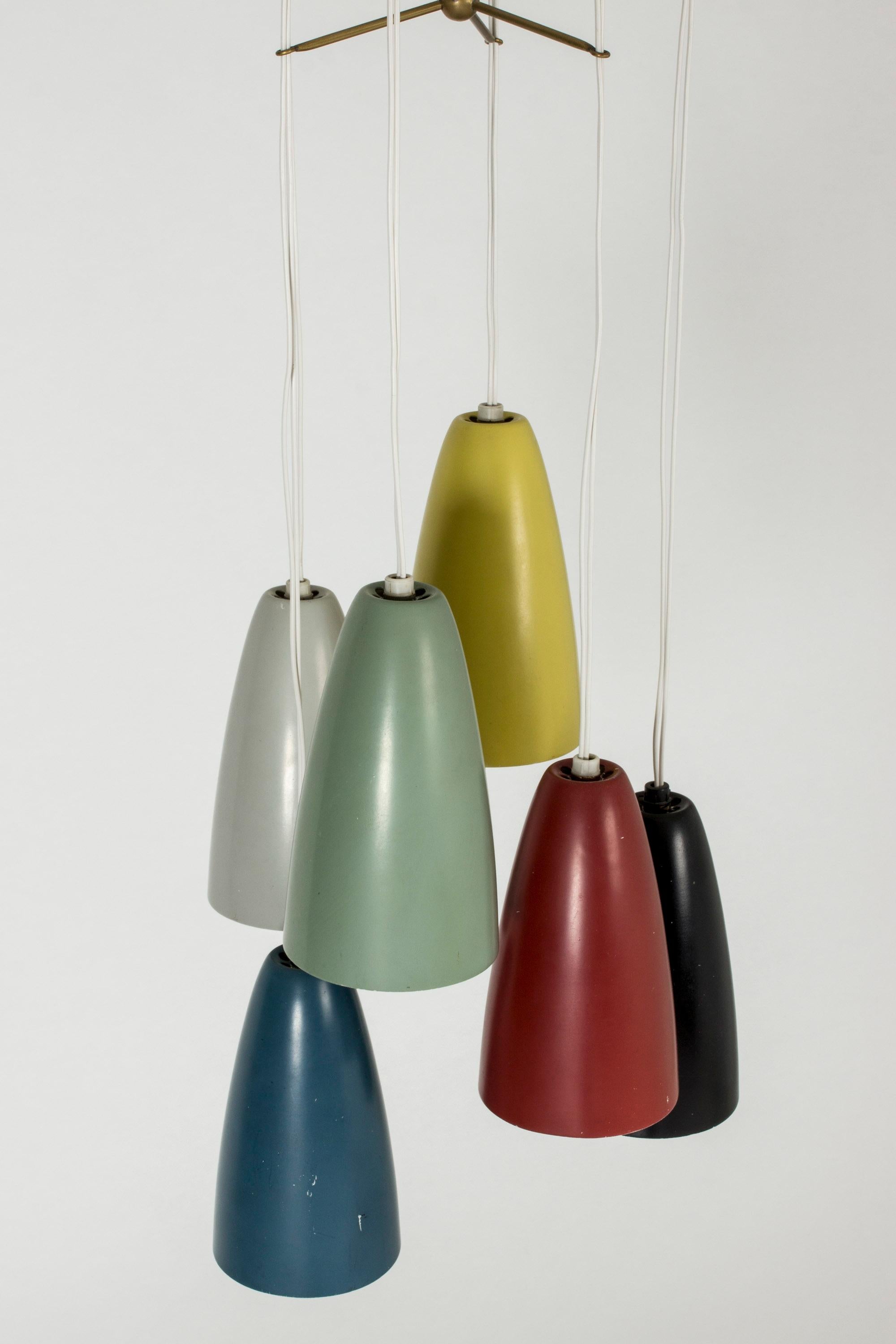 Sorprendente y singular lámpara de techo con múltiples pantallas de distintos colores, de Hans Bergström. Seis tonos en rojo, amarillo, azul, gris negro y verde polvoriento, cuyos cordones están recogidos por barras de latón que salen disparadas de