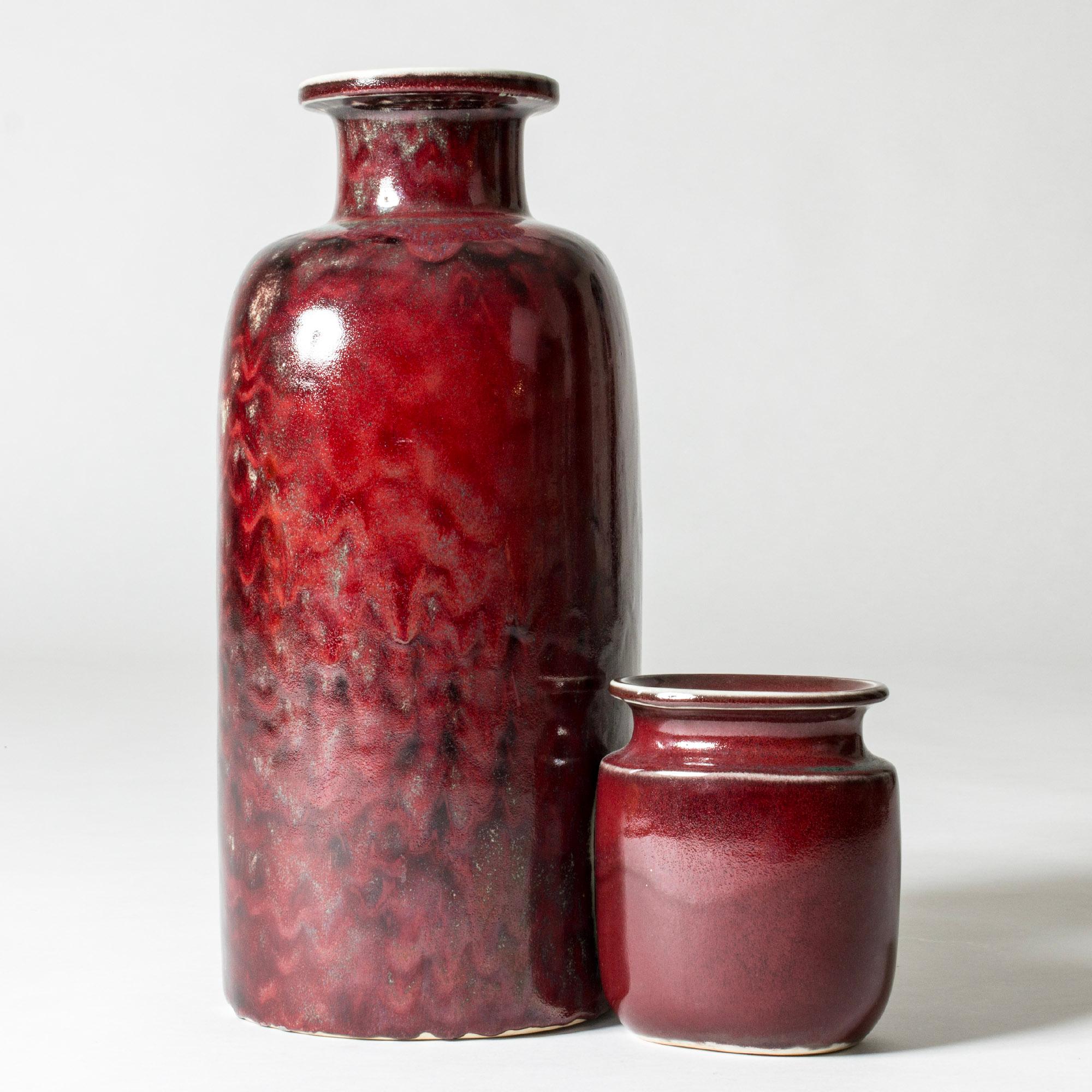 Unico vaso da terra in gres di Stig Lindberg, con un design stravagante di un vaso grande e uno piccolo attaccati l'uno all'altro. Forme slanciate con smalto rosso sangue ricco e vibrante con strati acquamarina.