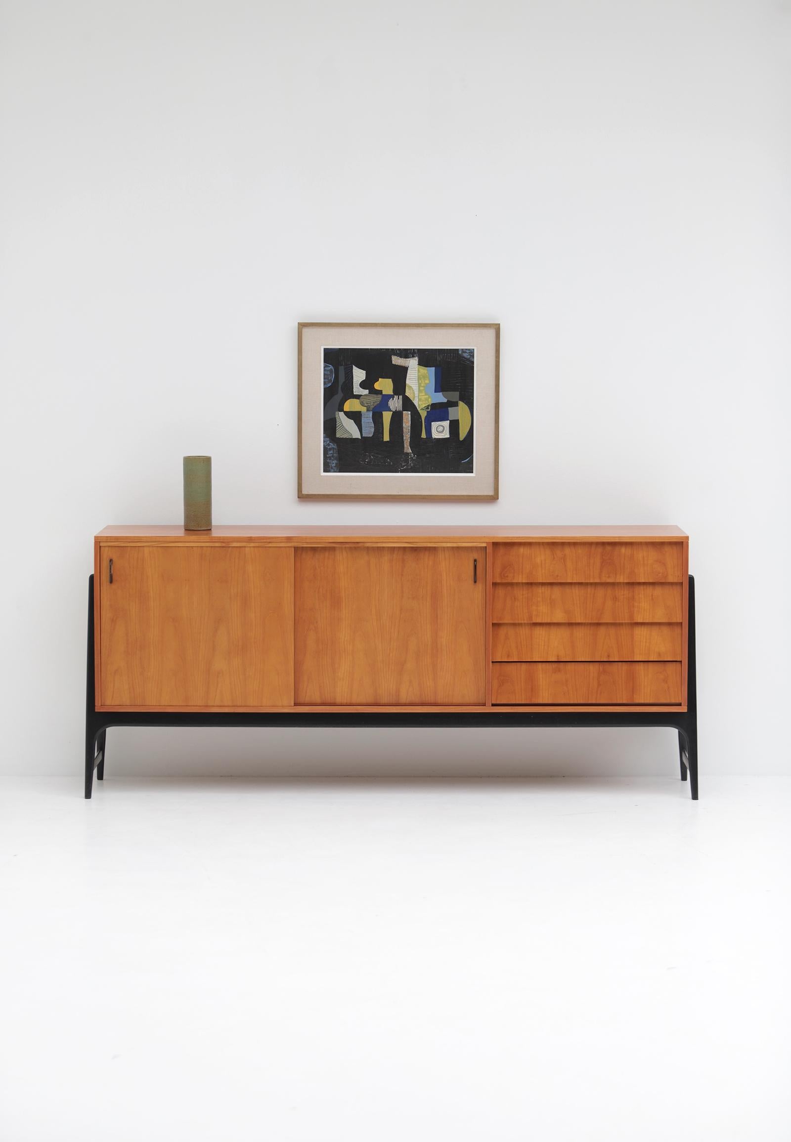 Unique sideboard by Alfred Hendrickx designed in 1958 for Belform. This sideboard is becoming more and more a unique find than a common find. Especially this edition in deep honey colored wood with drawers on the right side and sliding doors.