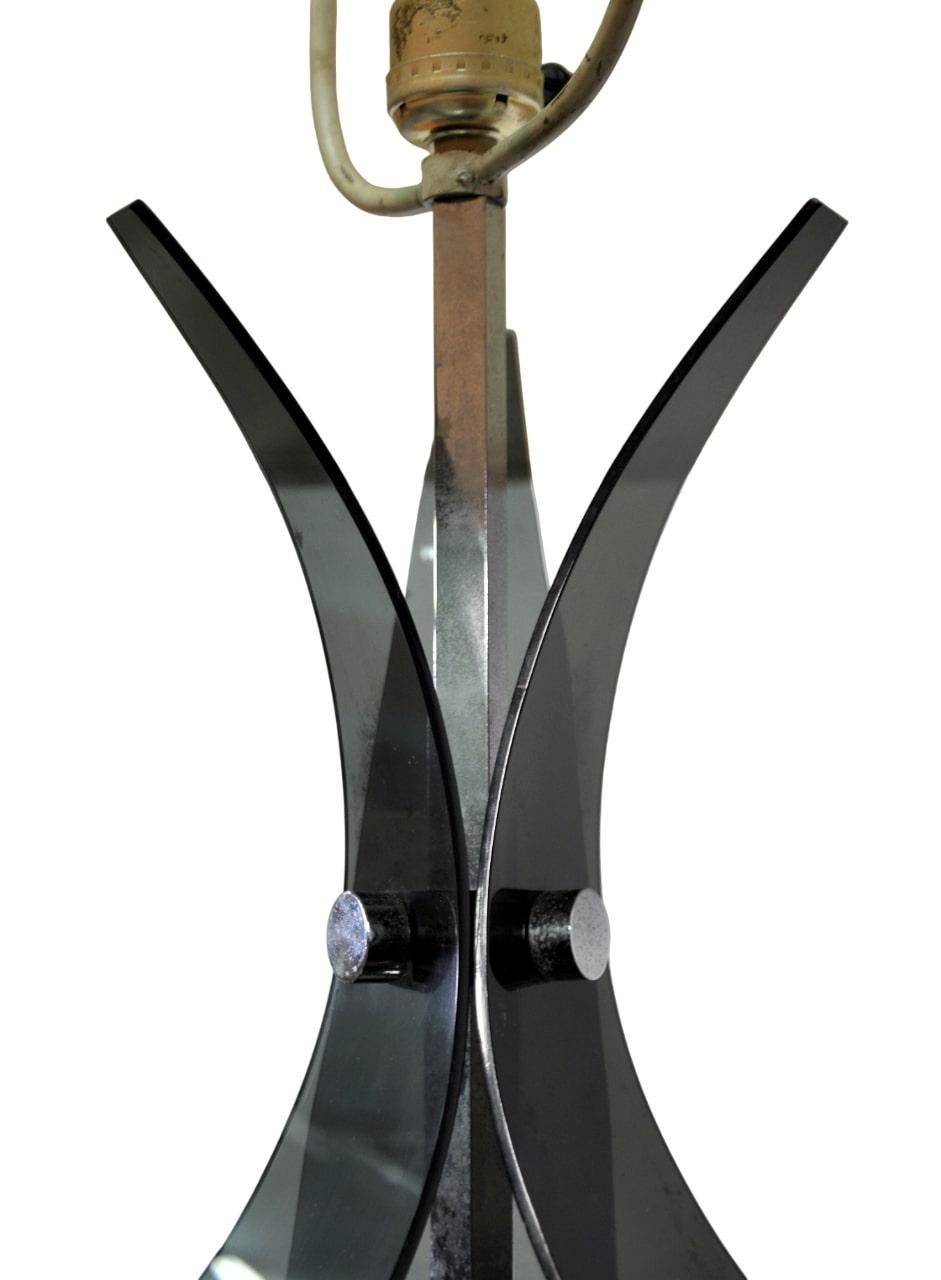 Very tall and funky Mid-Century modern smoked lucite and chrome table lamp from the 1970s elegantly blends vintage allure with a touch of contemporary sophistication. The vintage light features dark gray bent lucite elements nestled between a chrome