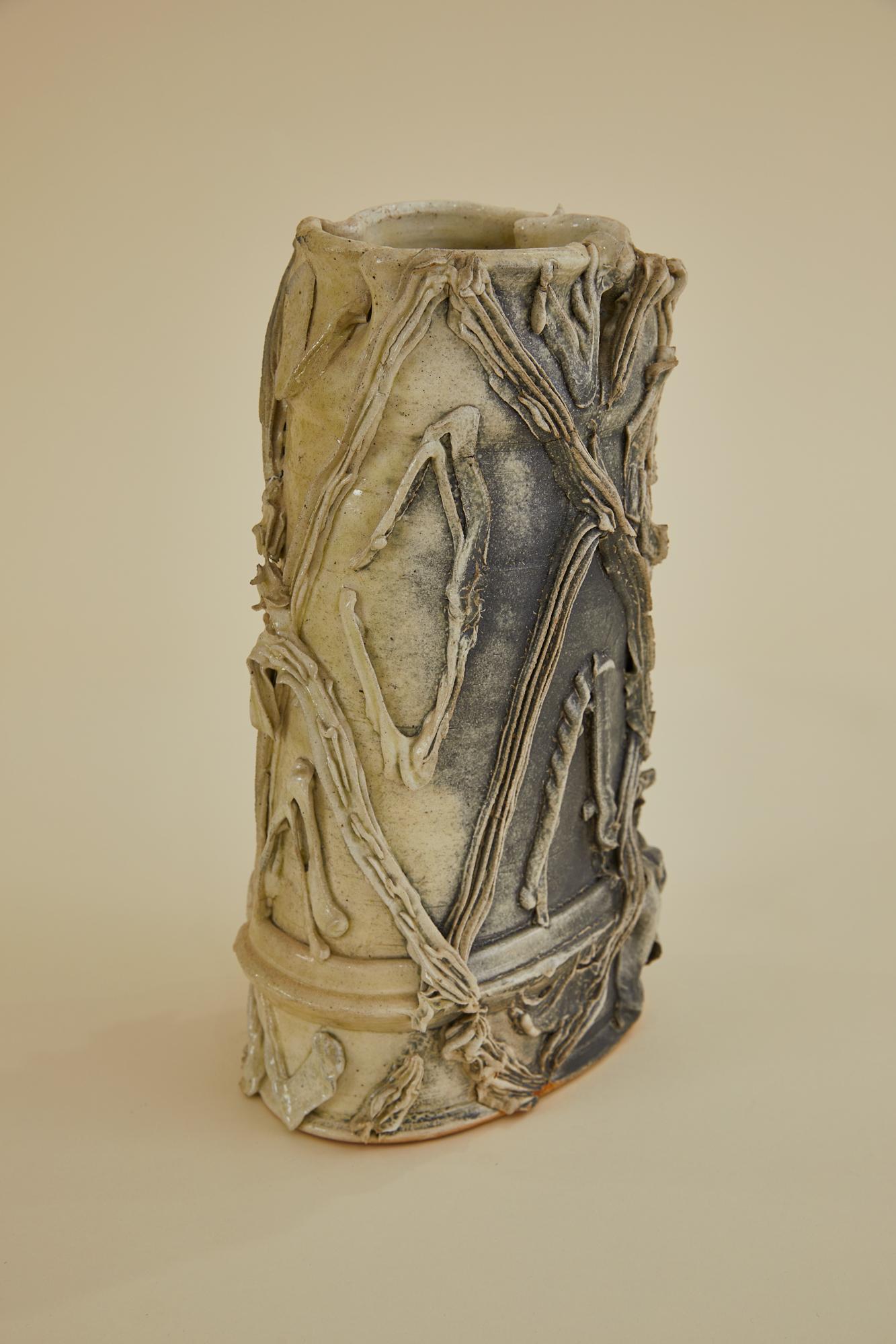 This is a one-of-a-kind ceramic vase of unknown origin. Perfect for long stemmed blossoms and tall greenery. The vase is asymmetrical in form with a handkerchief style opening. The exterior of the vase has a beautifully built up patina of with
