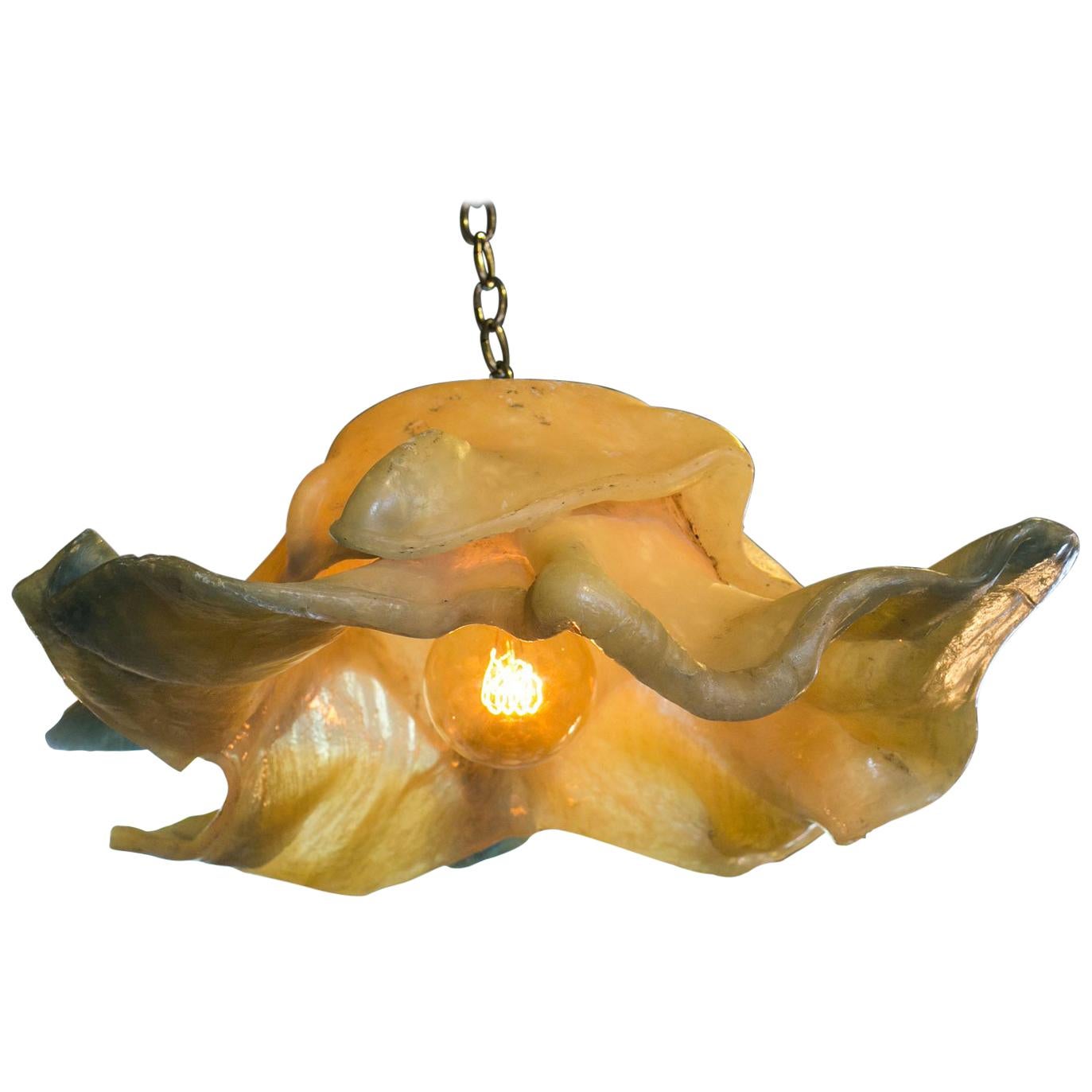 Unique modern fiberglass pendant light from Belgium. Hand-molded in an organic modern style from fiberglass. Nice, larger scale size. Color is more off-white neutral but a warm light will illuminate this fixture in a warm, amber or ochre hue (like a