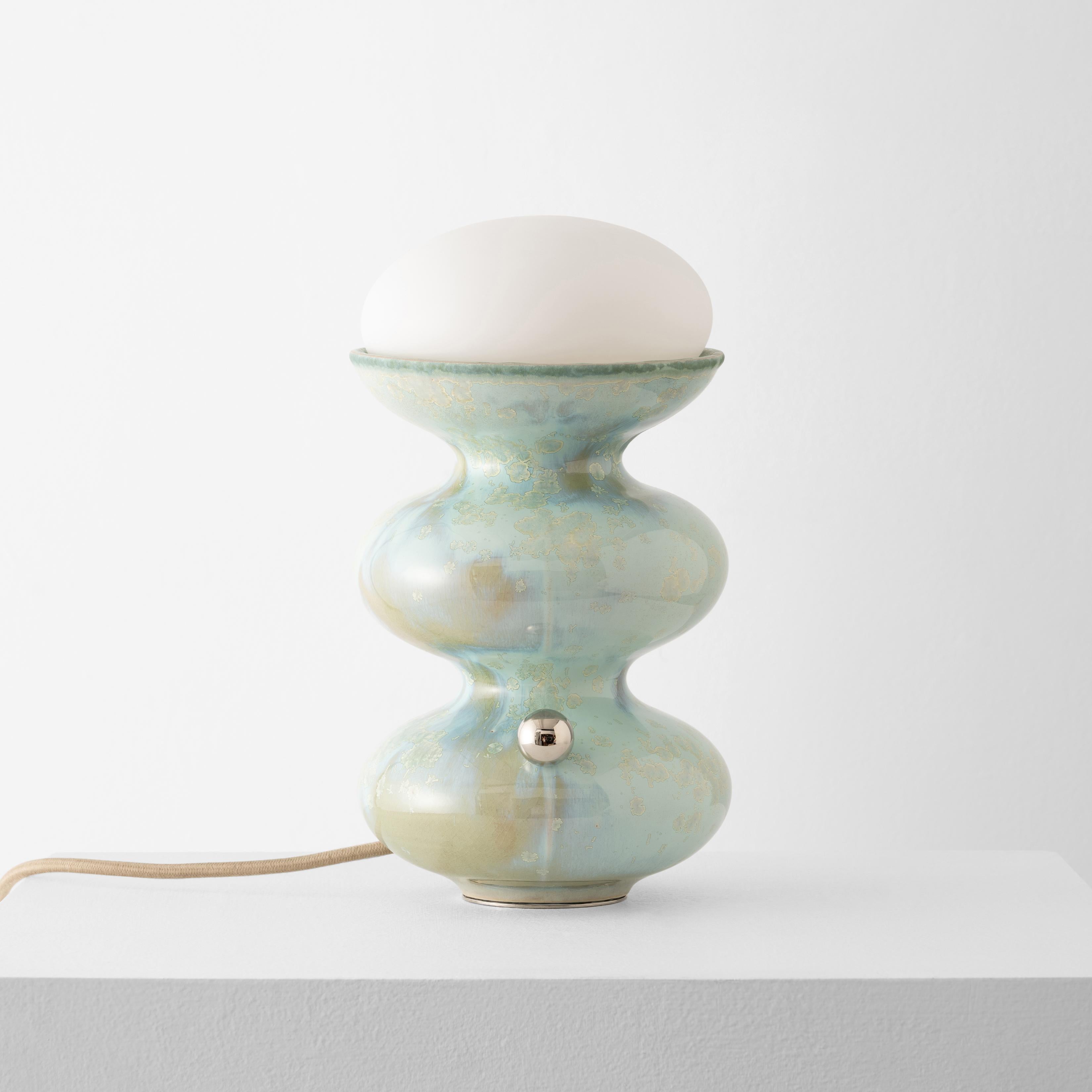 Notre lampe Kuwait Mini en Acqua est notre design classique et intemporel, développé avec une précision numérique et fabriqué à la main avec des émaux personnalisés uniques. Le corps en céramique est fabriqué à la main, tandis que les détails en