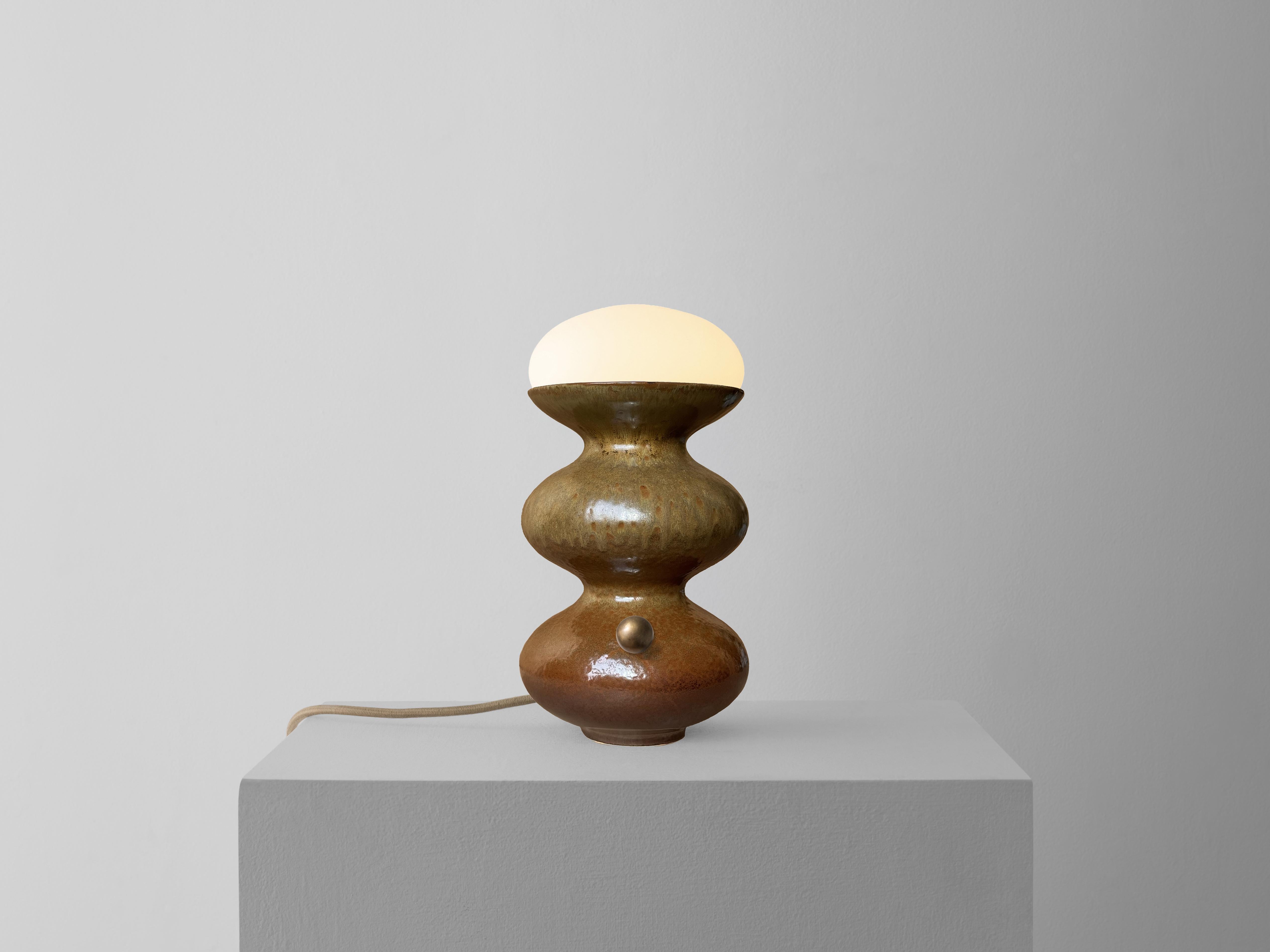 La nostra lampada Kuwait Mini in Dondo, marrone terra, è il nostro classico design senza tempo, sviluppato con precisione digitale e realizzato a mano con smalti unici e personalizzati. Il corpo in ceramica è lavorato a mano, mentre i dettagli in