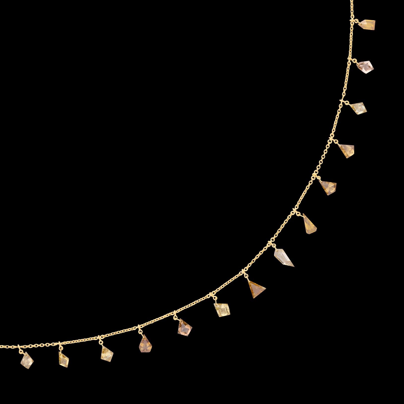 A true original! This 18 karat yellow gold necklace features a combination of 17 Yellow, Orange, Champagne and White Diamonds of varying cuts (kites, triangles, diamond cuts etc) weighing a total of 4.40 carats (averaging VS-SI), delicately dangling