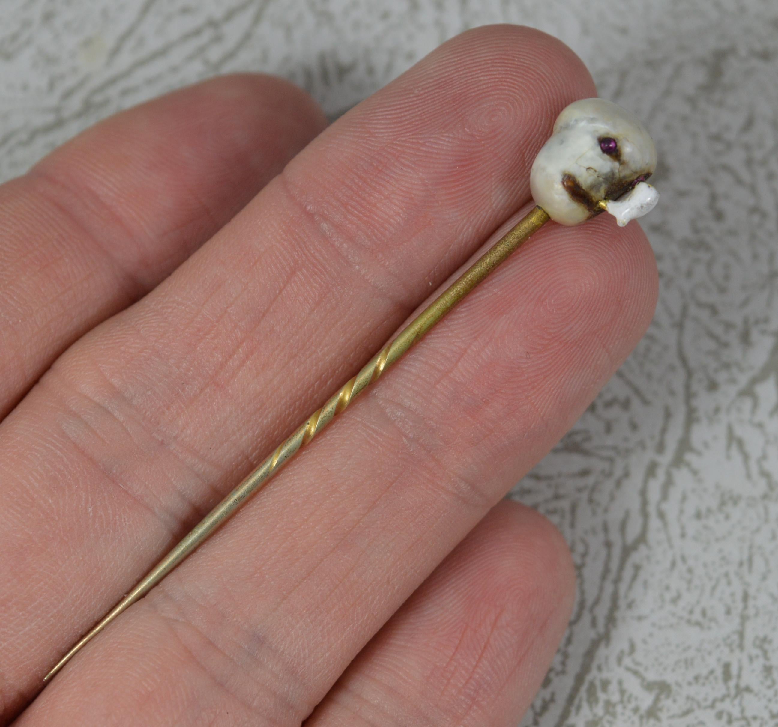 A superb stick tie pin.
Mid to late Victorian example.
Designed with a natural free form pearl which has then been expertly created into a head. The eyes are set with a ruby cabochon and the mouth is then holding an enamelled pipe.
Set onto a rolled