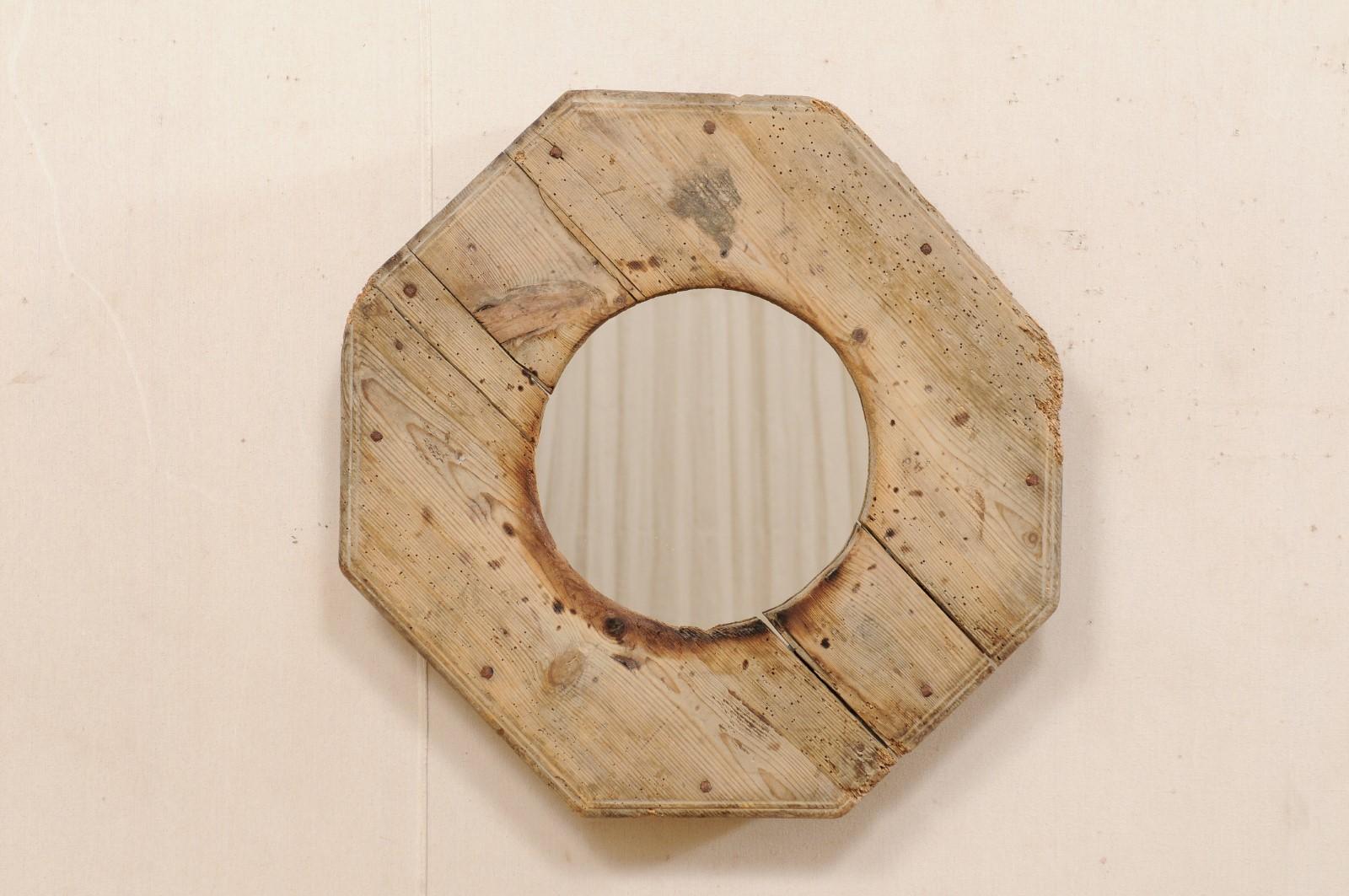 This unique mirror has been custom fashioned with an old N. African wooden cooking utensil as the surround, with new mirrored glass in it's center. This mirror features a circular-shaped mirror, within a rustic and octagonal-shaped wooden frame from