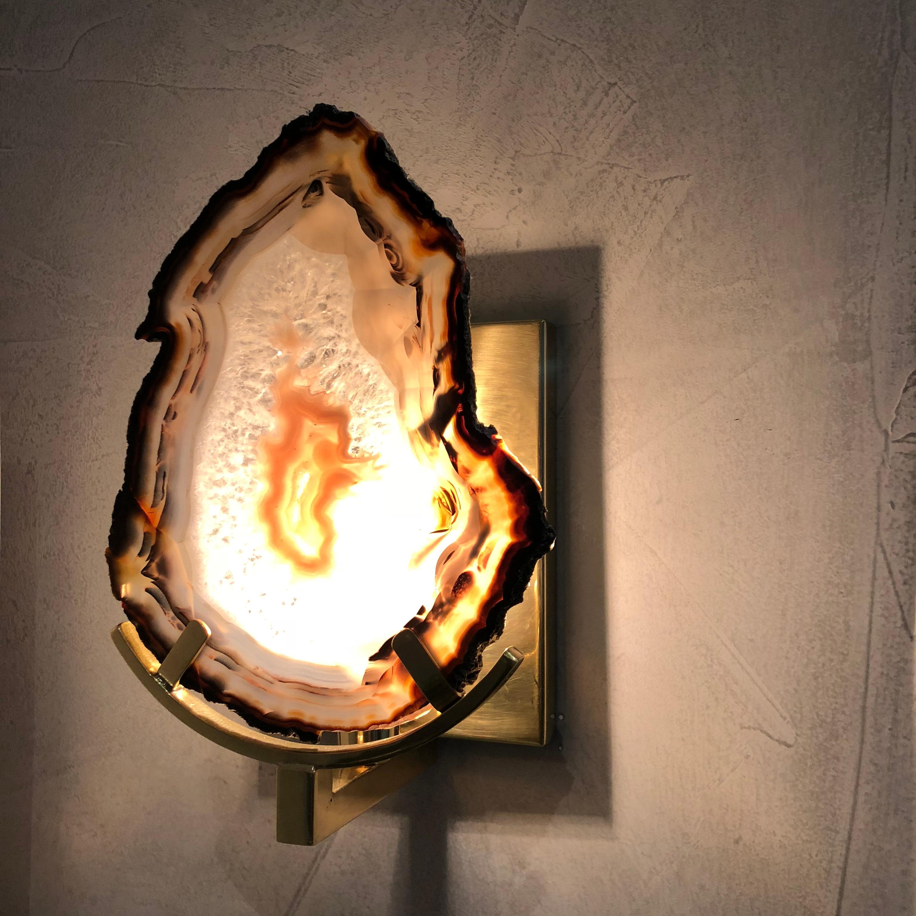 Unique sconces wall lamp created with Agate blades. In a round wall fixing panel made in polished and varnished brass.

The natural stone integrates with the different design languages, combining straight and sinuous curves in a sophisticated