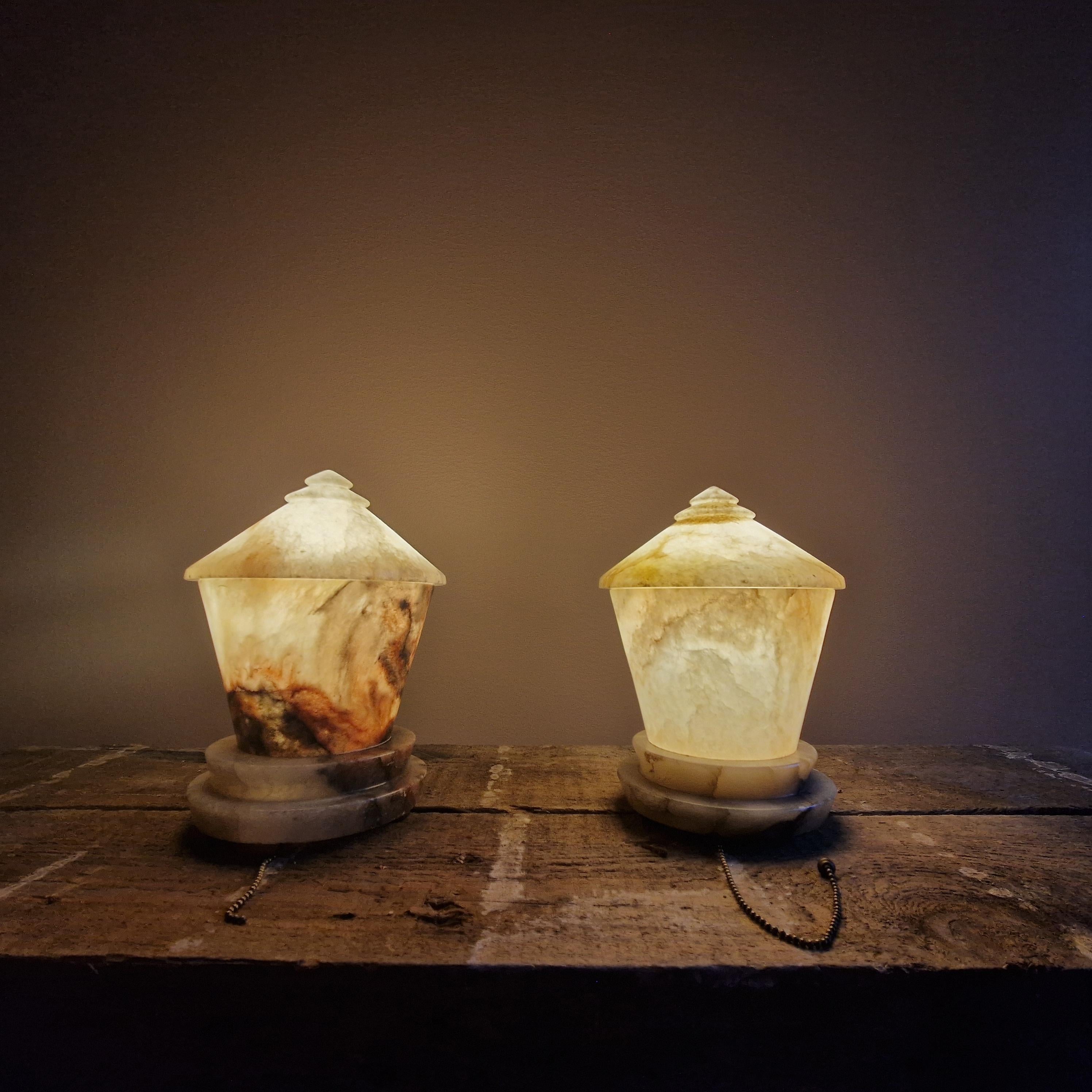 Paire de lampes de table en albâtre art déco. 1920/30s. Forme conique. Une magnifique paire de lampes qui fournit une merveilleuse lumière chaude. 

Bon état. L'un des couvercles est marqué par une ancienne ampoule trop chaude. Il manque l'embout