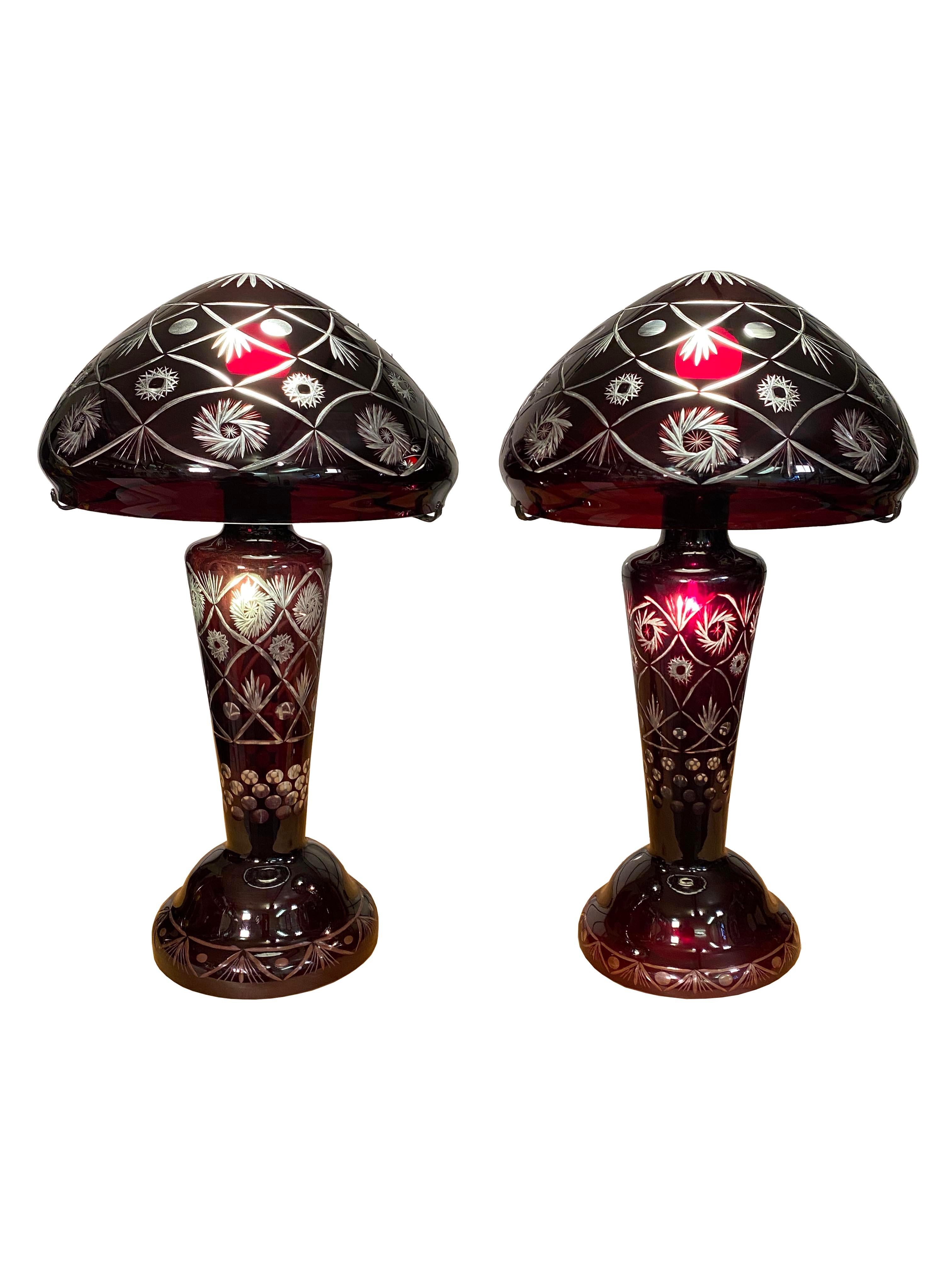 Trasforma il tuo spazio con queste affascinanti lampade in vetro a forma di fungo, testimonianza di maestria e arte. Realizzata in vetro rosso bordeaux intenso, ogni lampada vanta intricati dettagli incisi a mano che aggiungono un'aria sofisticata e