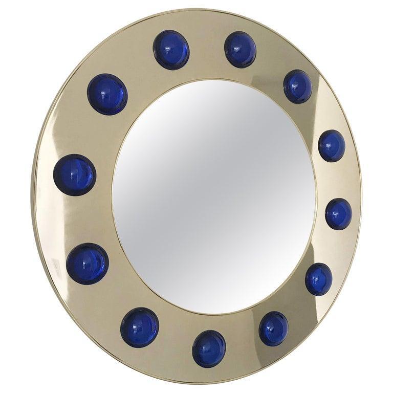 Round pair of mirrors in polished brass finish decorated with large dark blue Murano glass hemispheres / made in Italy measures: diameter 47 inches, depth 3 inches.