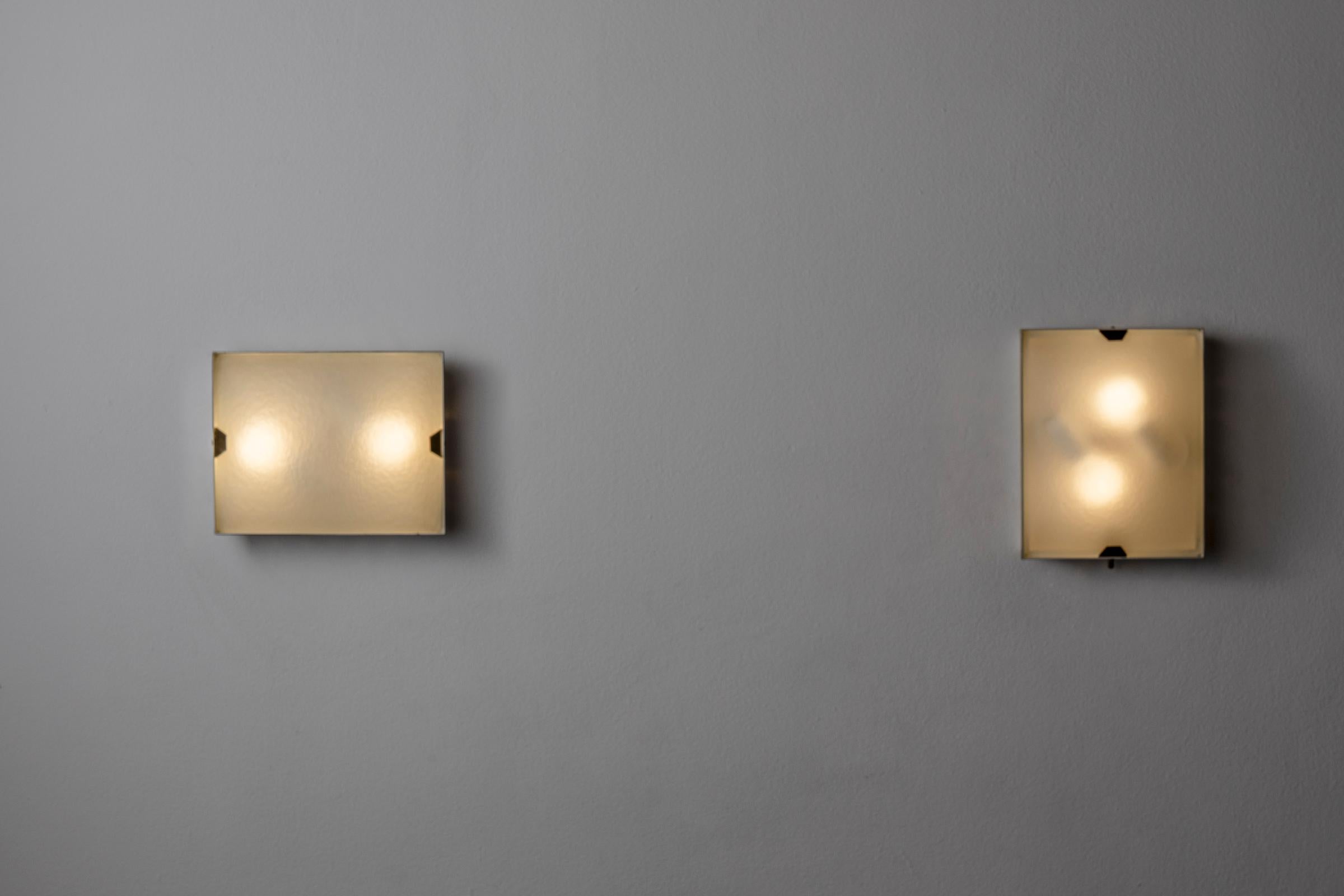 Unique Pair of sconces by Stilnovo. Manufactured in Italy, circa 1950's. Brass, glass. Wired for U.S. standards. We recommend two E14 60w maximum bulbs per fixture. Bulbs not included.