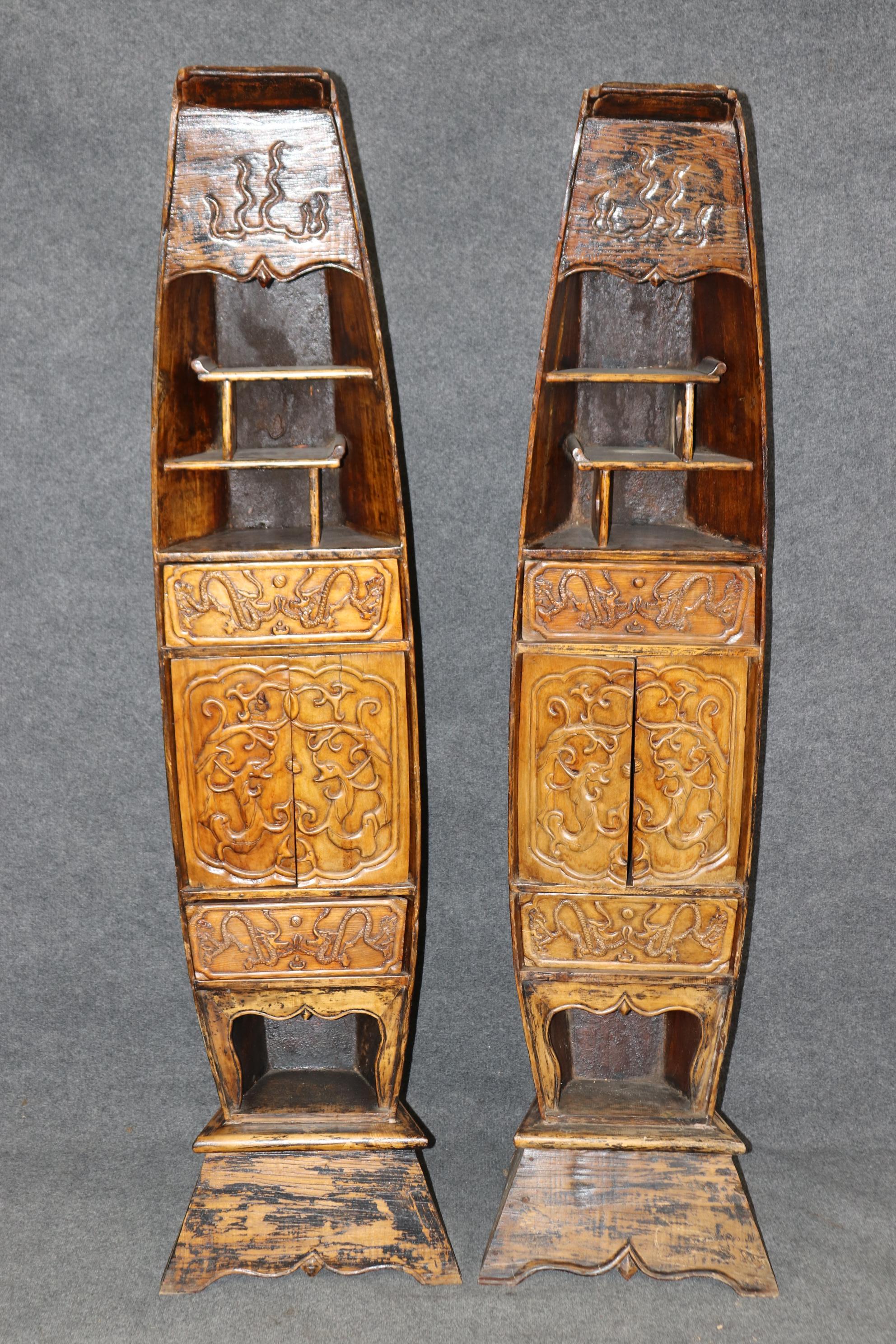 Il s'agit d'une paire unique d'étagères en forme de canoë. D'une forme incroyablement rare, ils présentent leur finition d'origine, des dragons sculptés fantaisistes et des étagères aux formes intéressantes. La finition présente une usure et des