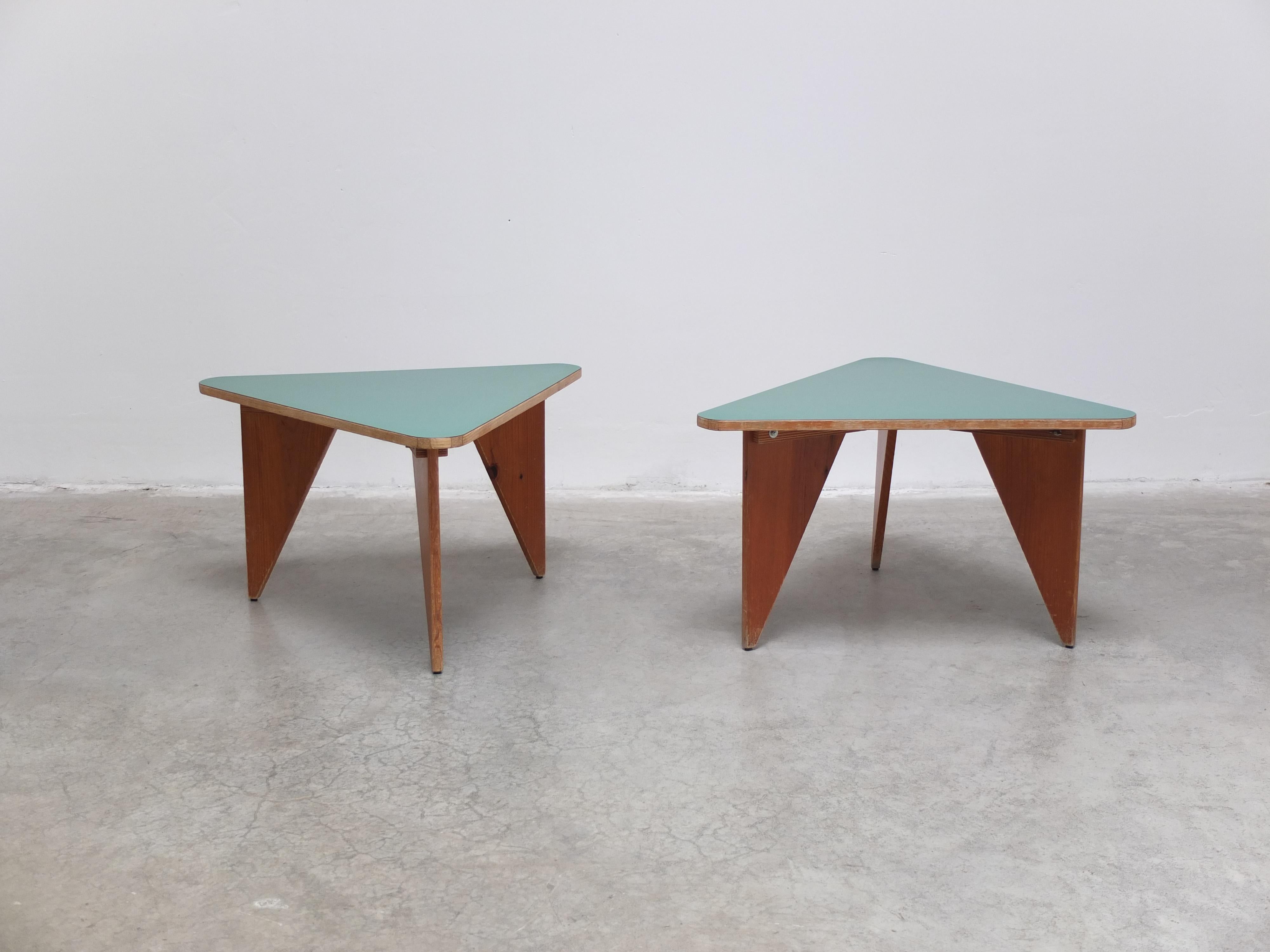 Remarkable pair of side tables produced in France around 1960. The tops in triangular shape are made of a nice green formica and the decorative legs have a beautiful patina. A very playful pair that can also be used together to form one large coffee