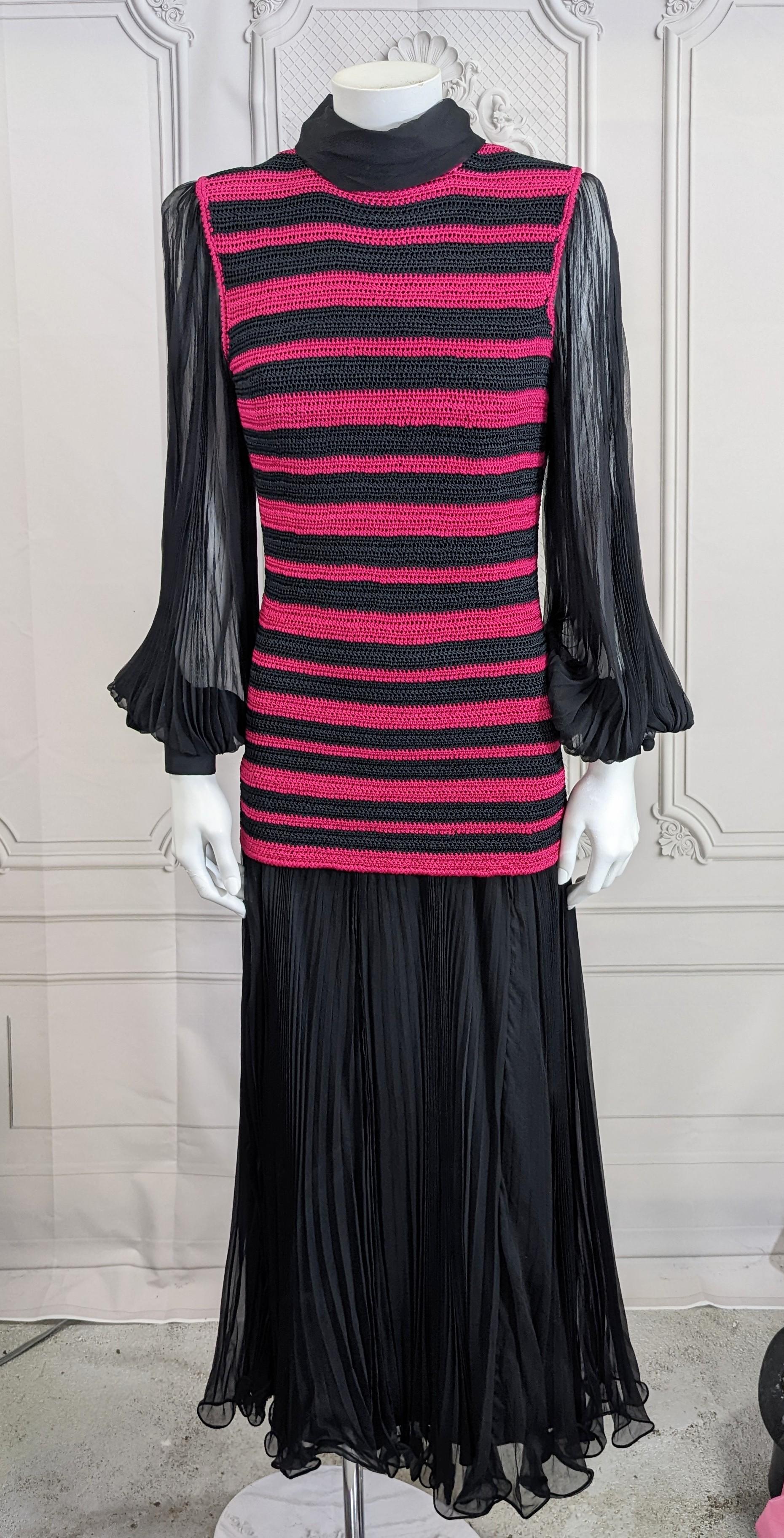 Unique and dramatic Paule Nelson Crochet and Silk Chiffon Pleated Gown, Italy. Black silk chiffon fully knife pleated skirt and sleeves are attached to hand crochet striped tunic in black and fuschia. 
Beautiful quality construction from a rare
