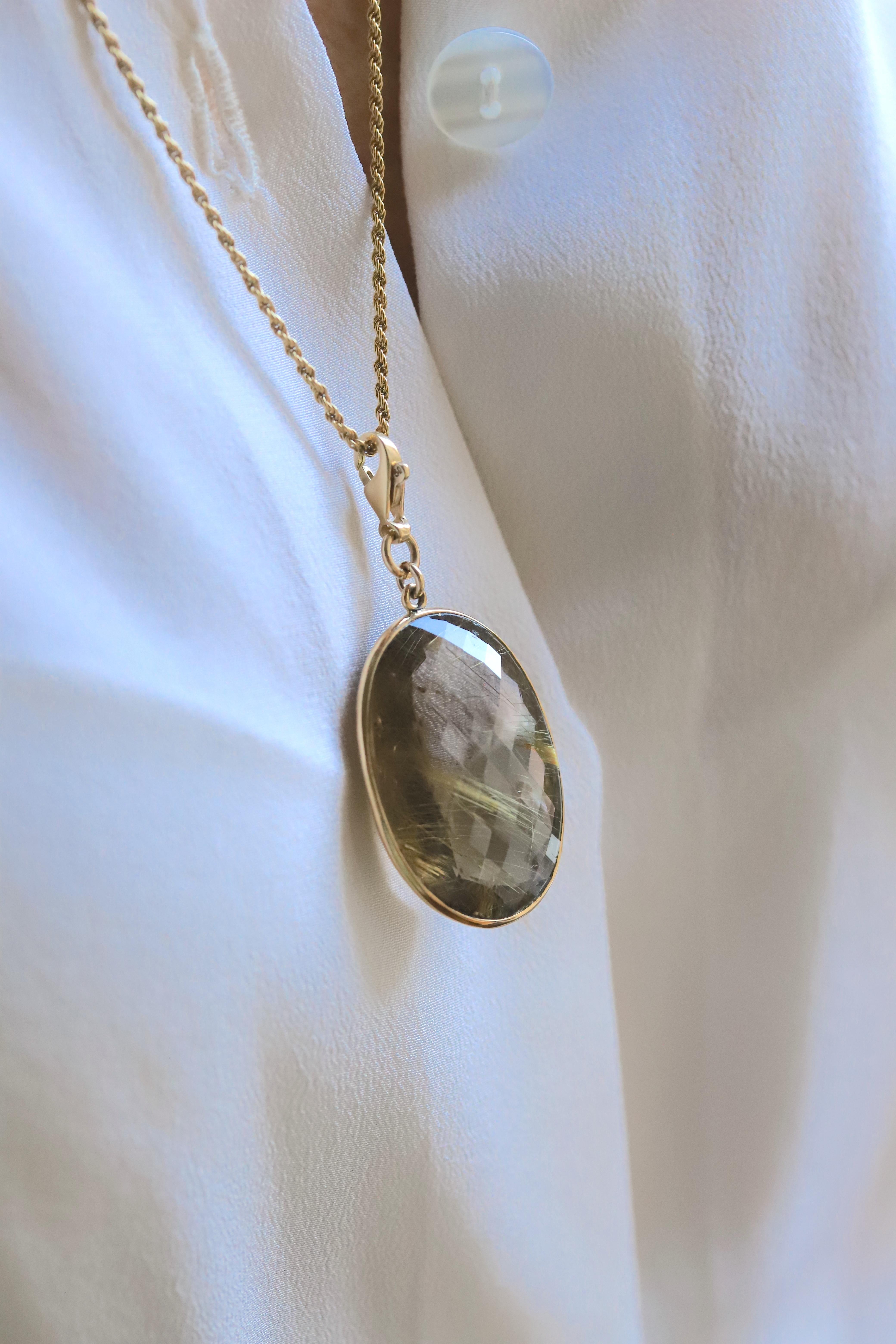 Rossella Ugolini Design Collection, One-of-a-kind  Rutilated Quartz Oval cut Charm set on a 18 Karat Yellow Gold bezel hang on a 18K Yellow Gold chain Necklace.
Dimension: Oval Rutilated Quartz  W. 0.40 In x H. 1.18 In  (W. 2.5 x H. 3 cm) 
Chain