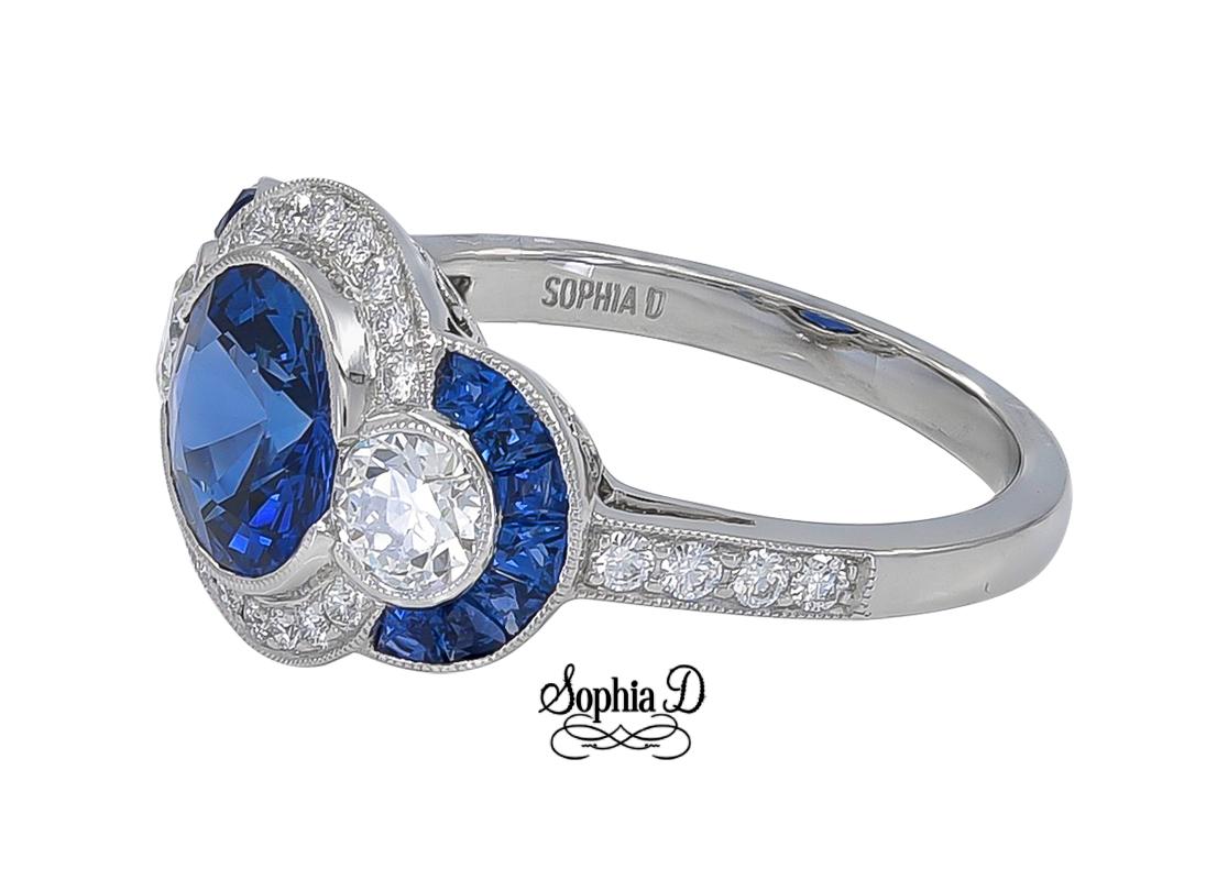 Sophia D platinum ring with an exquisite blue sapphire center weighing a total of 2.00 carat. Encompassing the center are round diamonds with the weight of 0.52 carat, sapphires weighing 0.40 carats and diamonds with the weight of 0.24 carat. Ring