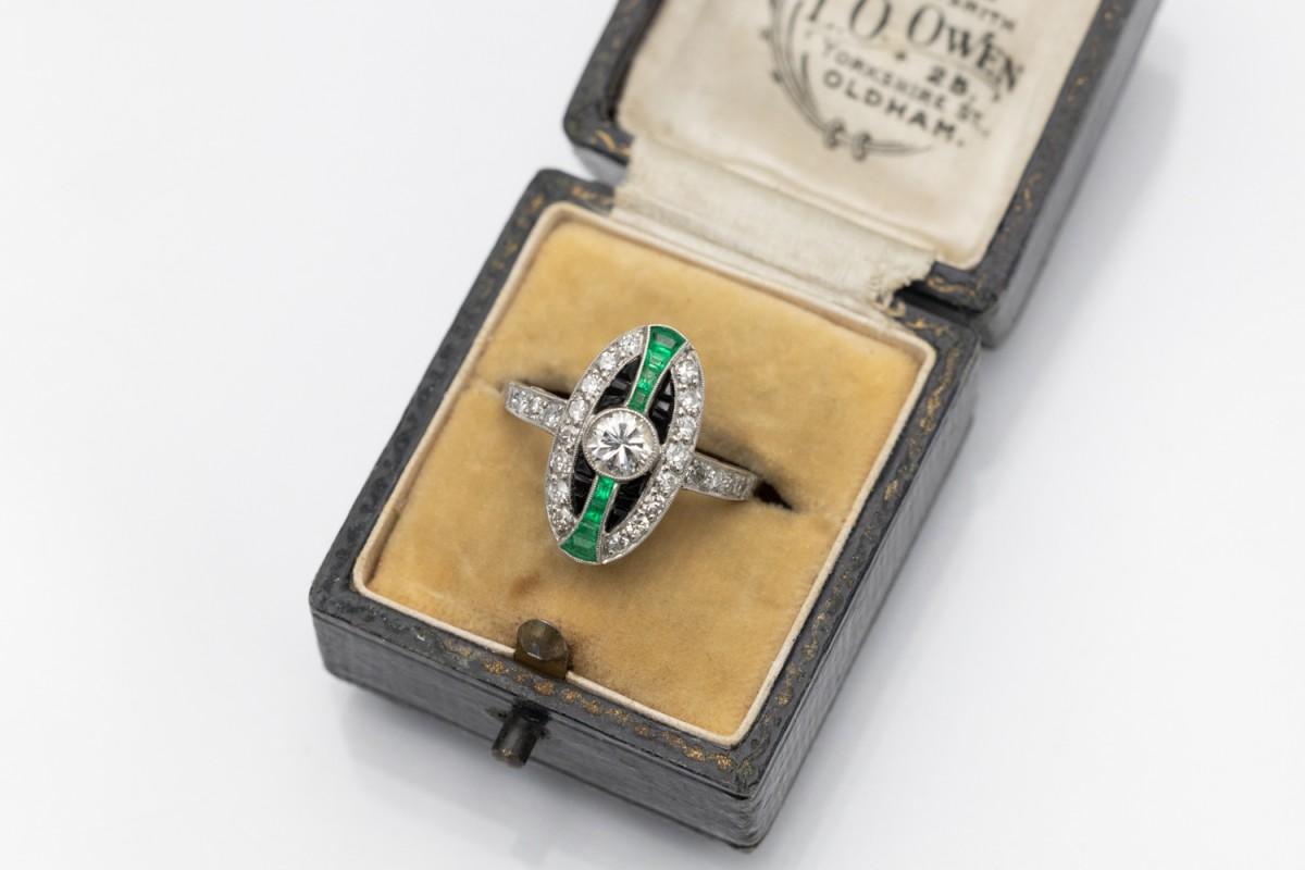 Platinum elongated ring, decorated with diamonds, emeralds and onyxes, whose geometric shape and combination of stones are characteristic of the Art Deco style.

Its central point is a brilliant-cut diamond weighing 0.47ct (colour and clarity I1),