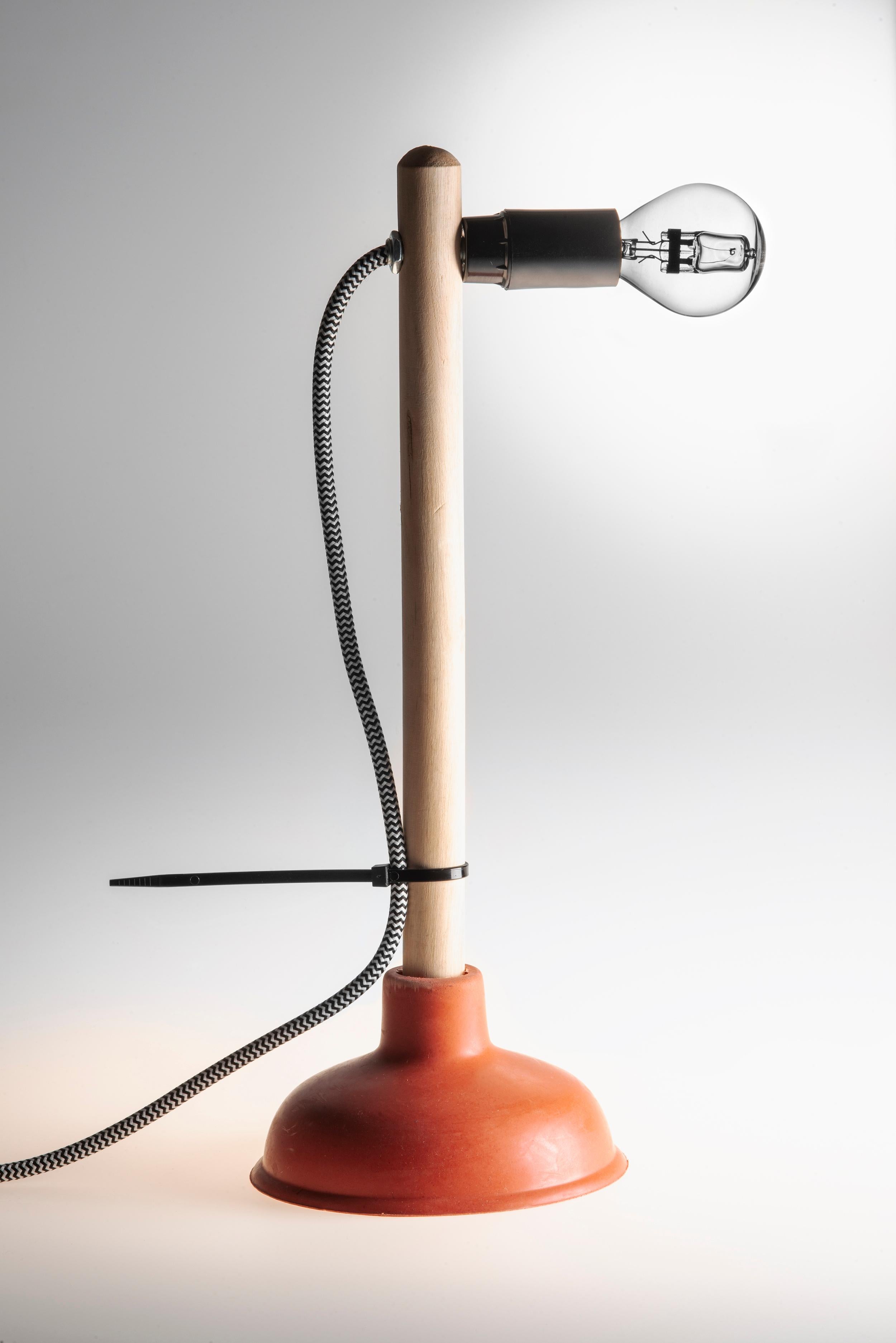 “Plunger” is a unique handcrafted table950 lamp by Josep Maynou, created using a plunger and basic electrical components sourced from local hardware stores during his travels around the world. Each lamp is a unique piece, assembled by the artist