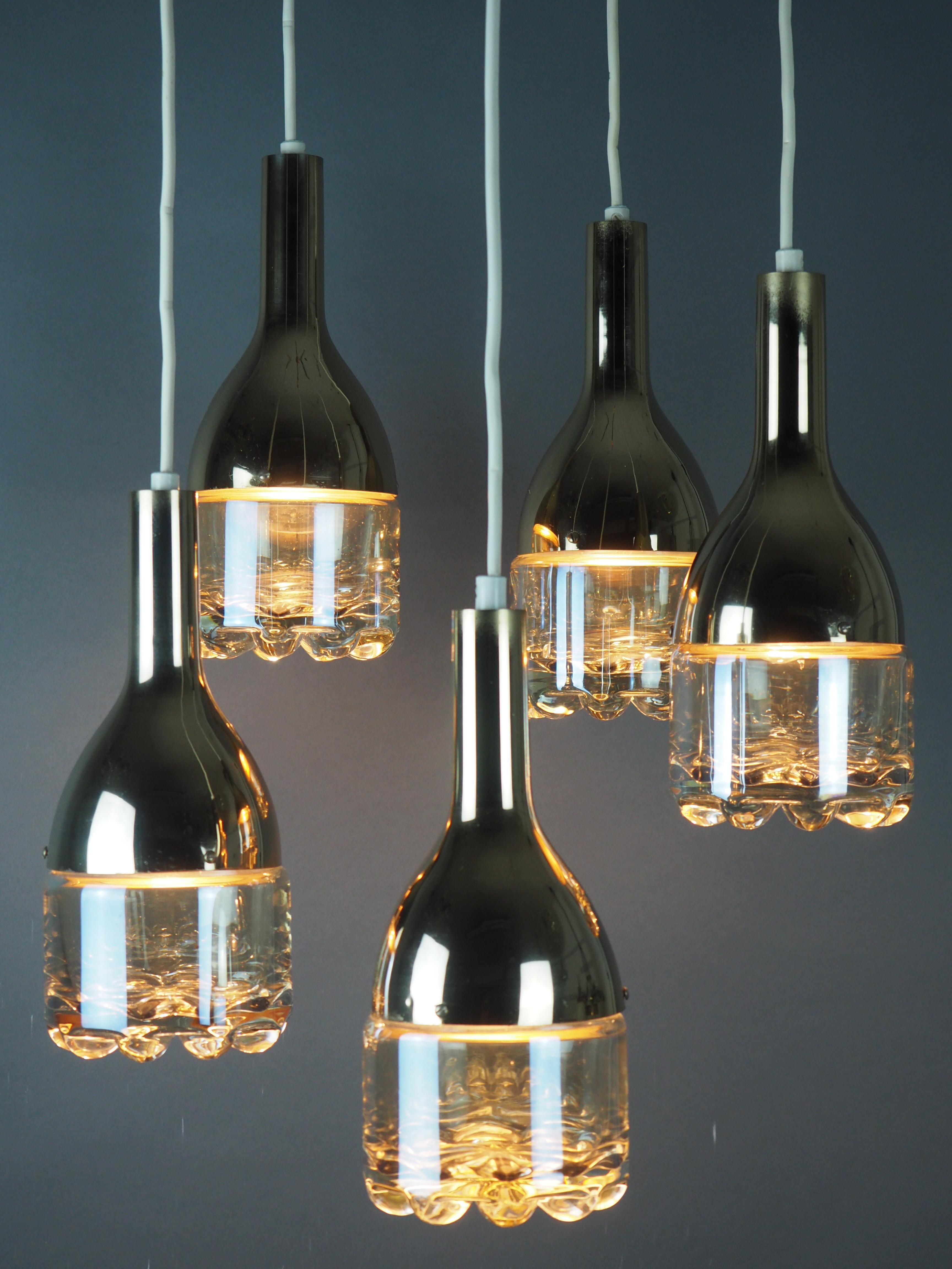 A  midcentury five -light glass pendant, Germany, circa 1960s.
Made of polished brass and thick heavy glass globes hanging.
Adjustable in the height.
Socket: 5x e 14 - three e14 (Edison) for standard screw bulbs.
 