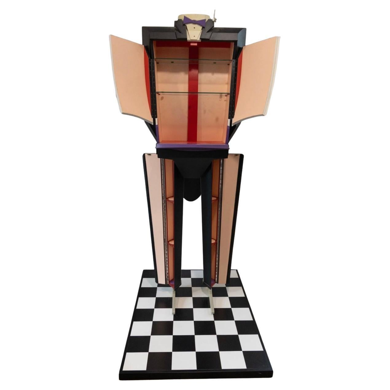 Unique Post Modern Pop Art Custom made Butler Tuxedo shaped figure dry bar liquor cabinet. Sculpted ColorCore Formica depicting a headless butler standing upright on a checkerboard floor platform with his hands behind his back. His torso opens and