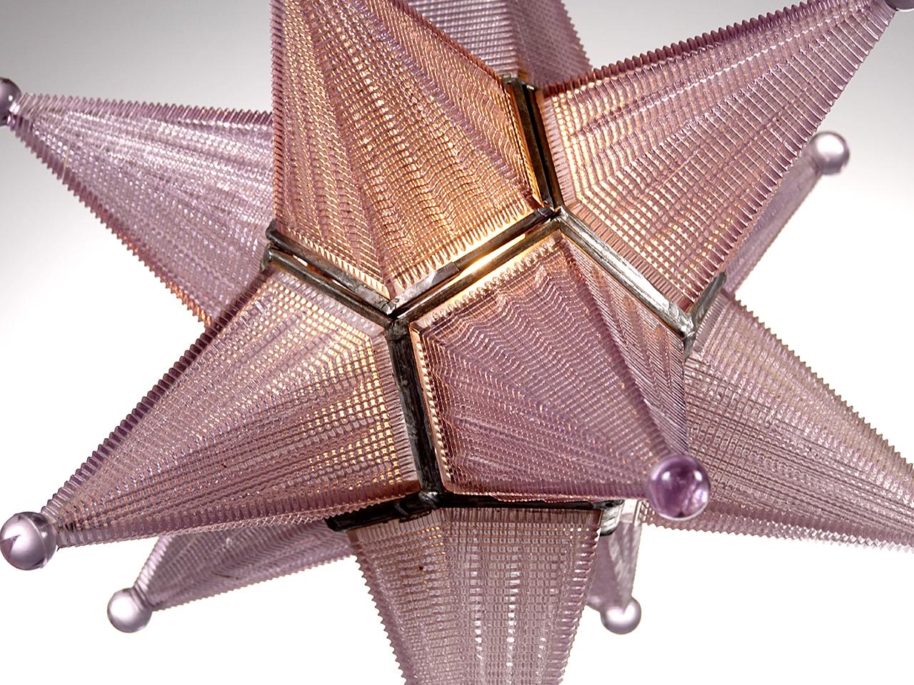 We have never come across a star lamp of this quality. Each star section is cast prismatic glass. The glass also has a lavender cast to it. The tint happens over years of use and is part of the patina and aging process for some types of glass. The