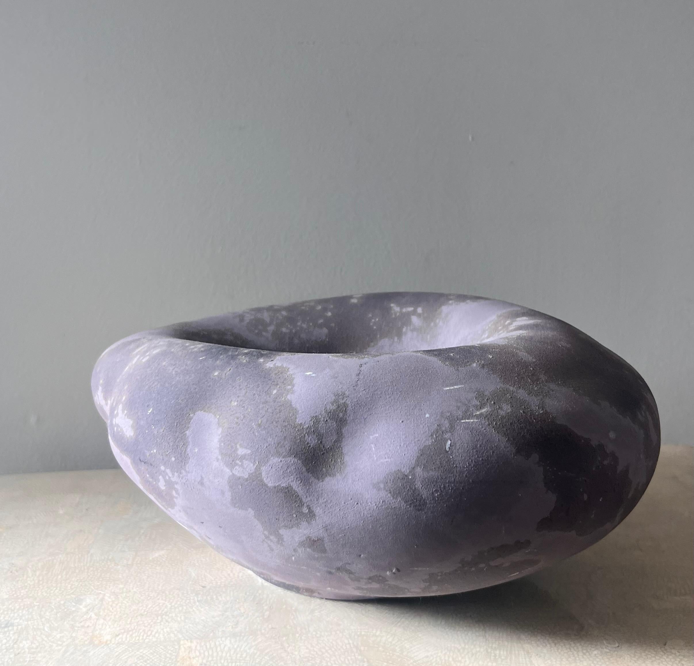 An incredible artpiece raku pottery centerpiece by Tony Evans, signed, early 21st century. In tones of lavender and violet and featuring a raw rough finish. Great condition with minor scuffing.
12.5” W x 9.5” D x 5.5” H 