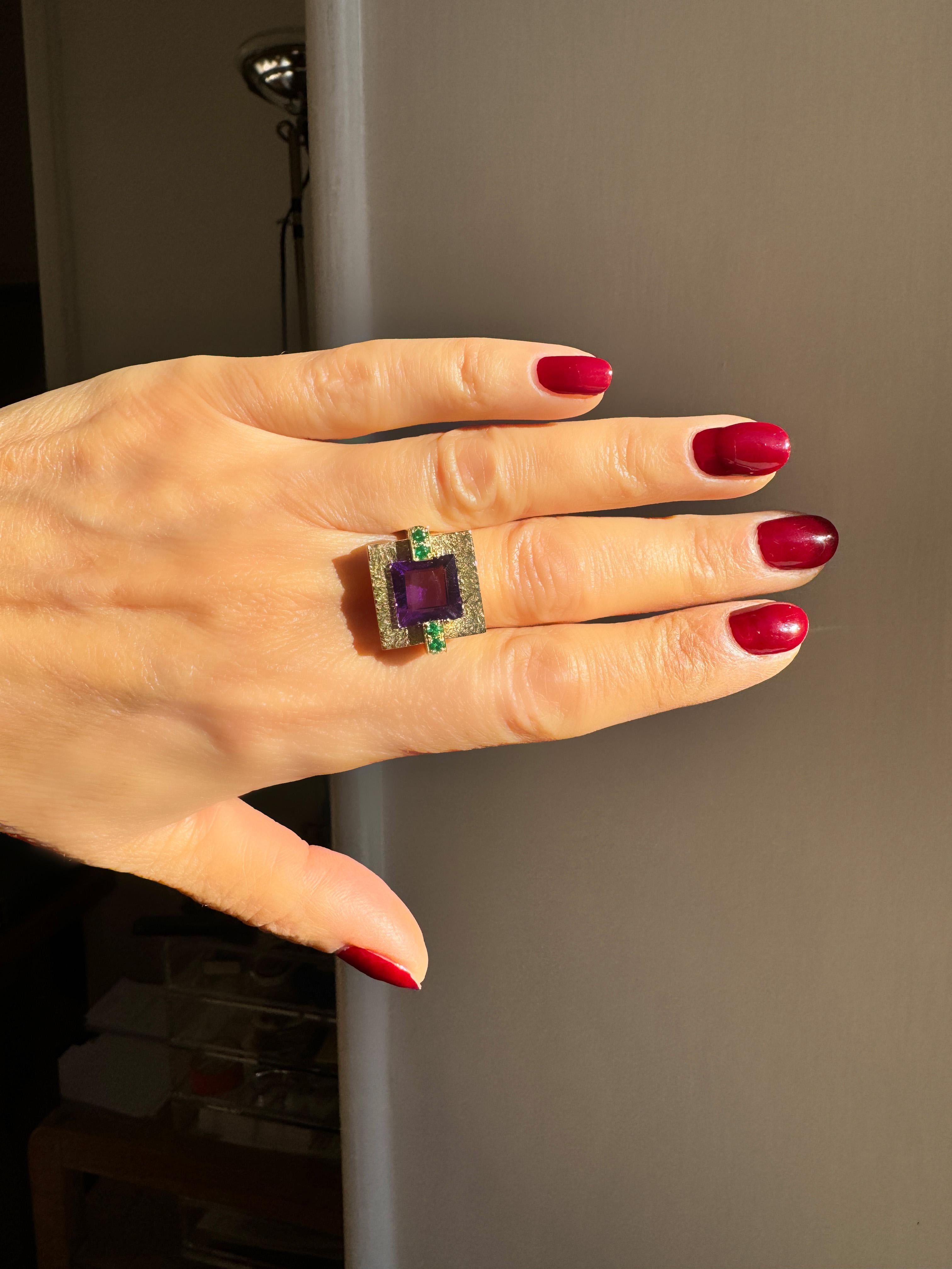 Unique Rossella Ugolini 18k Yellow Gold Amethyst and Emerald Cocktail Ring Hammered Design, Made in Italy
This exquisite cocktail ring, crafted in 18k yellow gold, showcases a stunning Deco-inspired design. The centerpiece is a square hammered gold