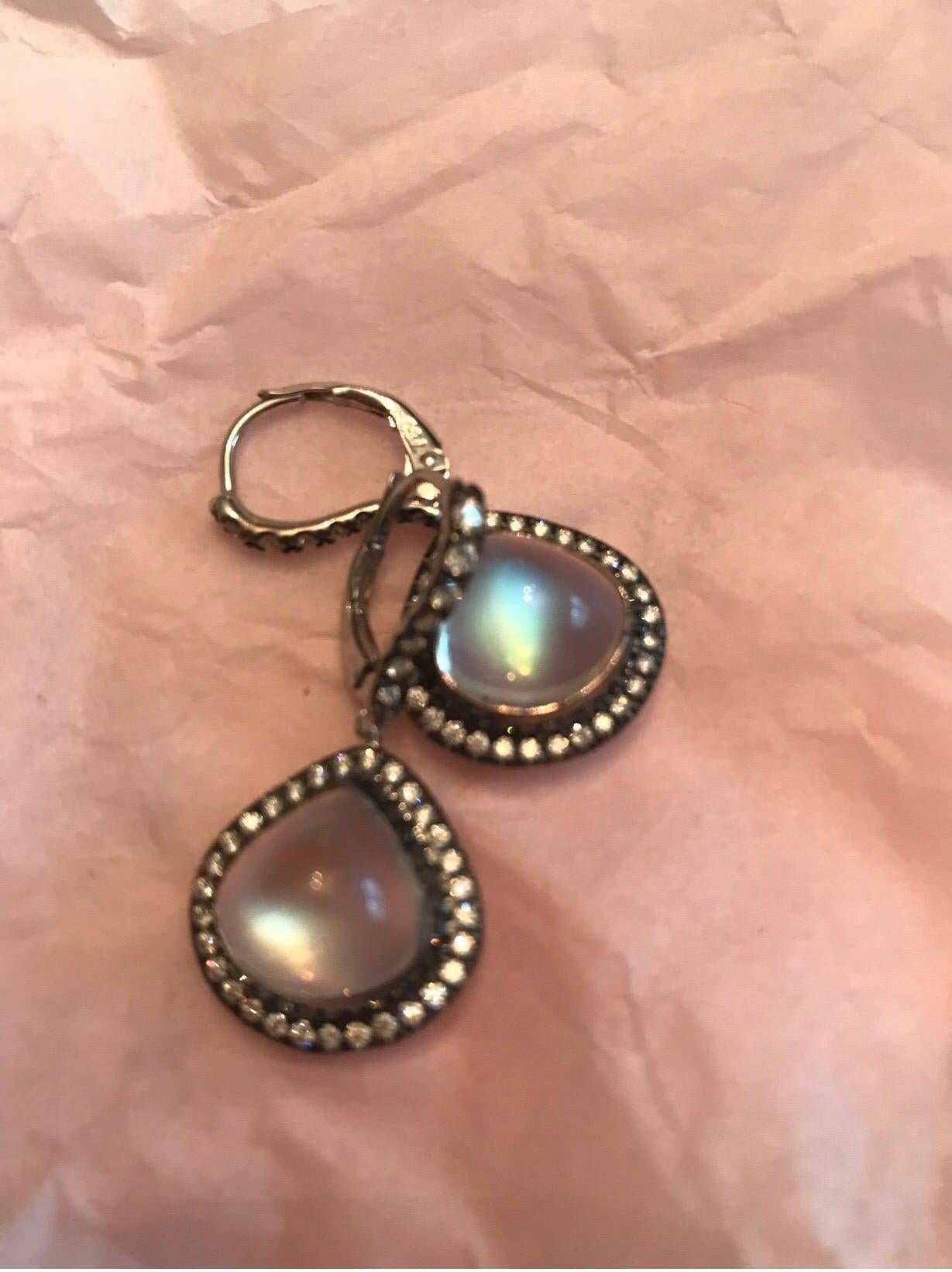 These Magnificent Pear Shape Royal Blue Moonstones  are set in 18 K White Gold, Accented With Colorless Diamonds, Black Rhodium Plated.  The Moonstones  in These Earrings Are Eye Clean and Display Strong Blue Primary Color, In Various Shades Of Blue