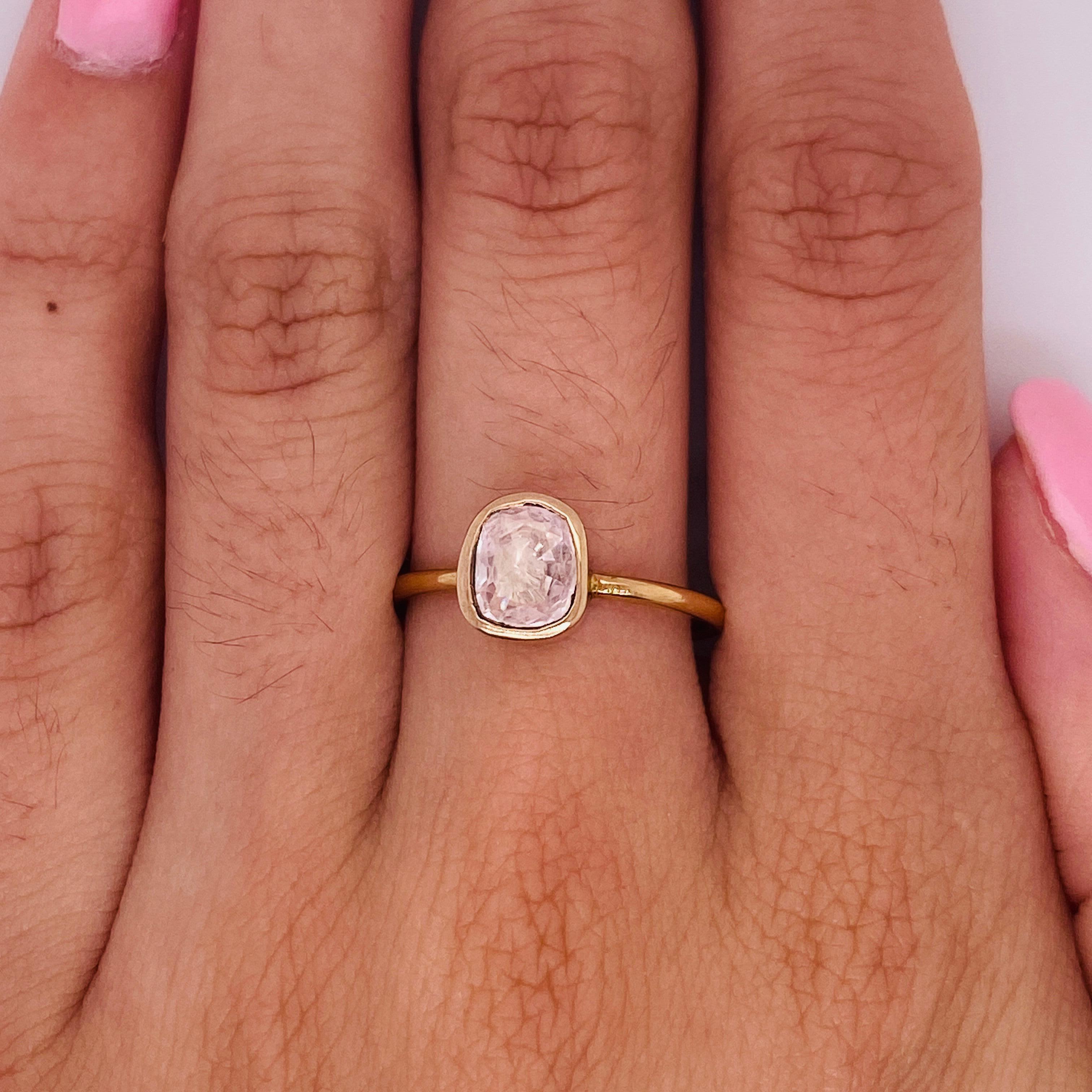 This unique ring is rich with pink! Much like the current trend in rustic salt and pepper diamonds, this pink sapphire has a rustic cushion shape and custom bezel. The ring is made entirely with 18 karat rose (or pink) gold. This rich pink gold is a