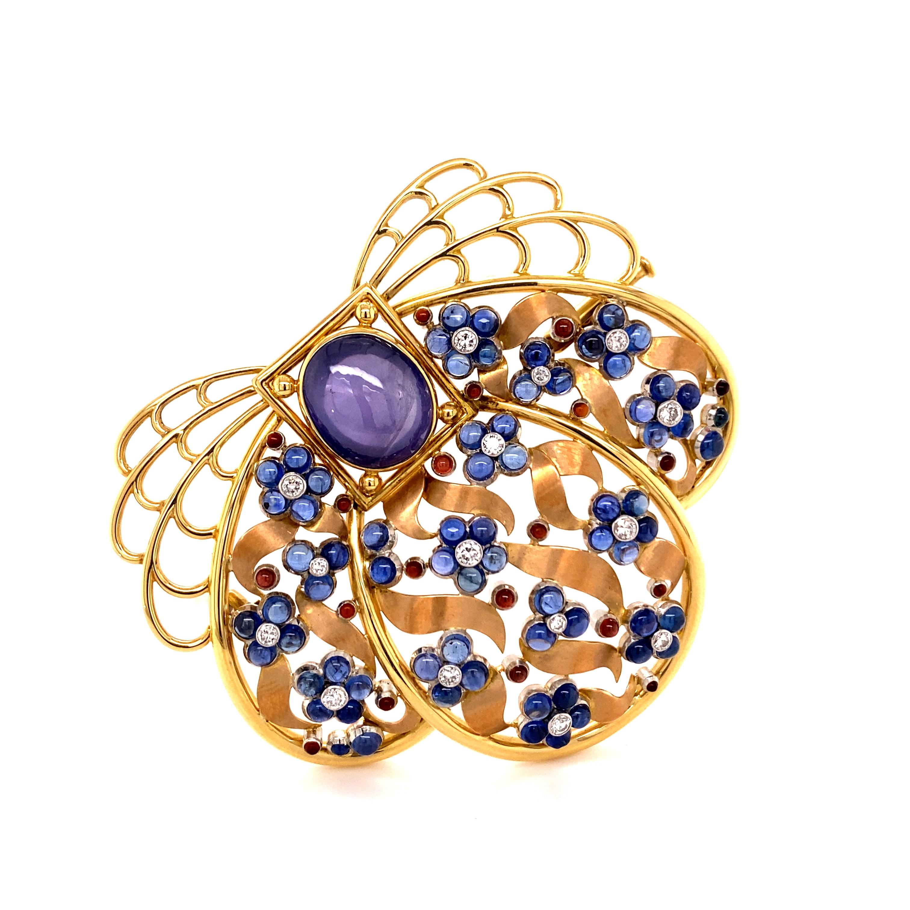 This beautiful and artfully designed brooch from the famous Swiss jeweller MEISTER is crafted in 18 karat yellow, rose, and white gold.
The centre is set with a transparent oval-shaped star sapphire of approximately 9.85 carats. The motif is