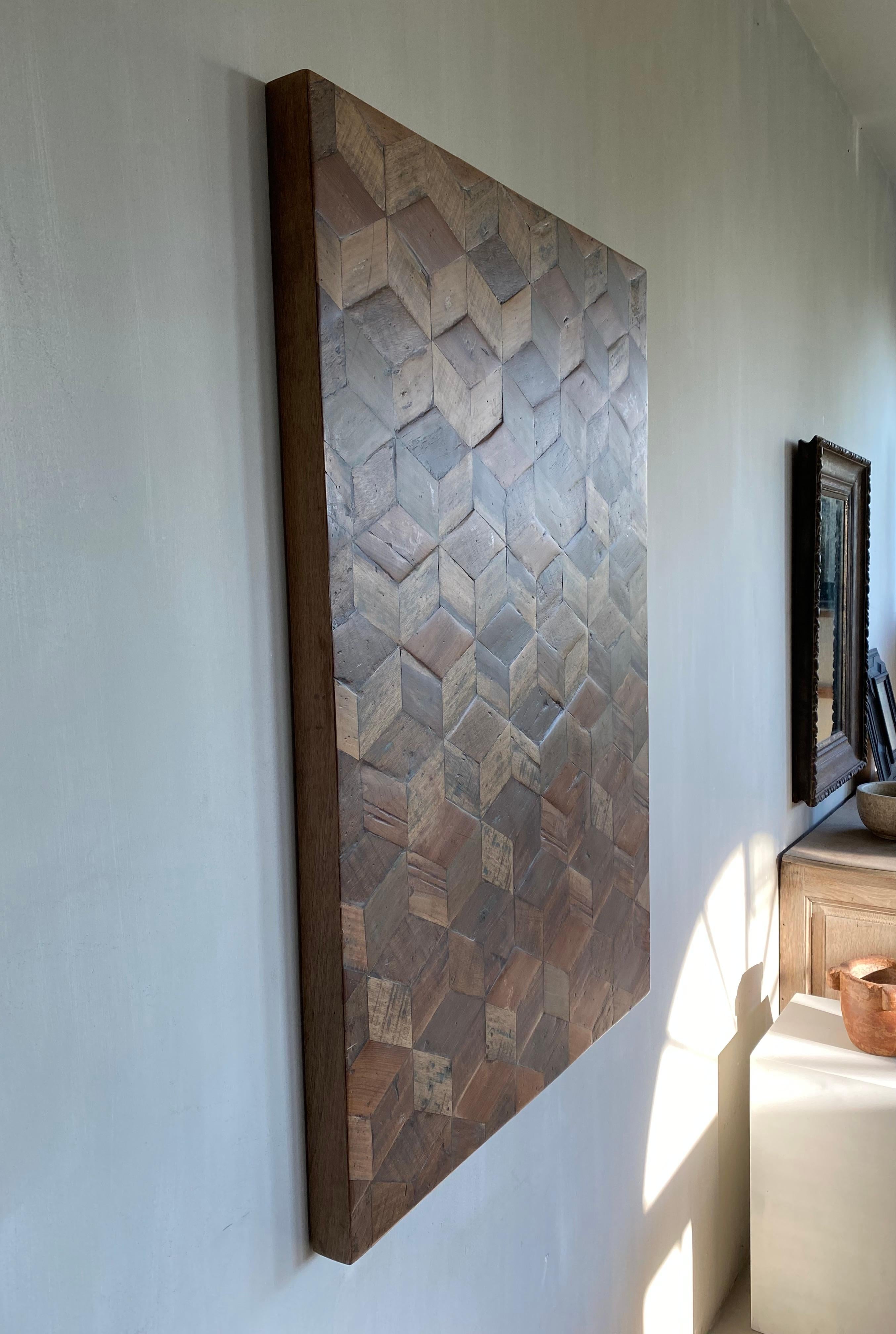 This beautiful craftwork by an unknown creator is a beautiful interplay of three-dimensional cubes in recycled wood.
The sculpted cubes stand on a wooden plate.

Earthy warm color tones give the whole a rest.
A vintage creation with a very