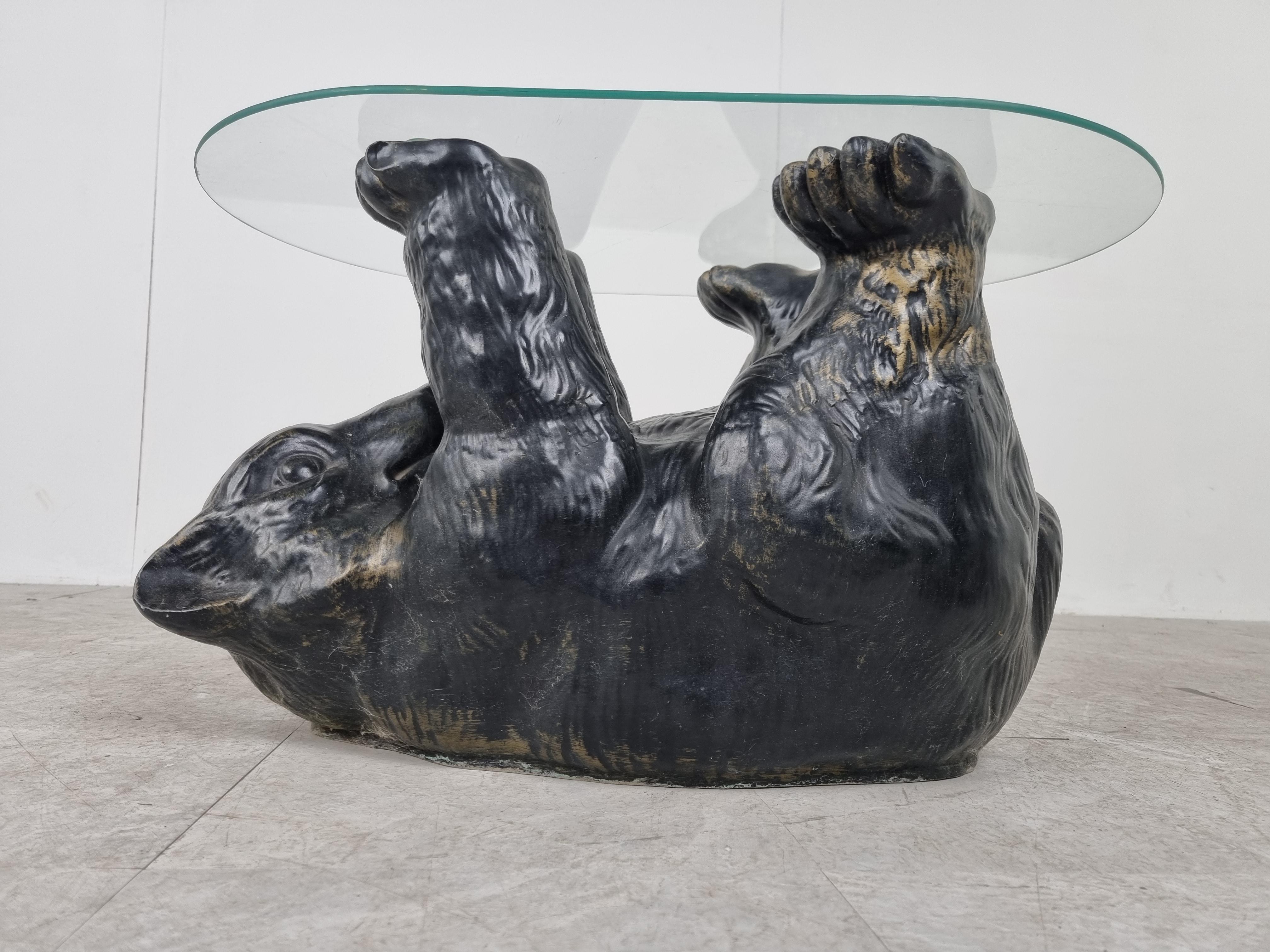 Eye-catching sculptural black bear coffee table.

This unique table looks great and somewhat cute.

The glass top can be changed if deemed too small. (inquire for info)

Made out of stoneware with a bronzed look.

1970s - Belgium

Good