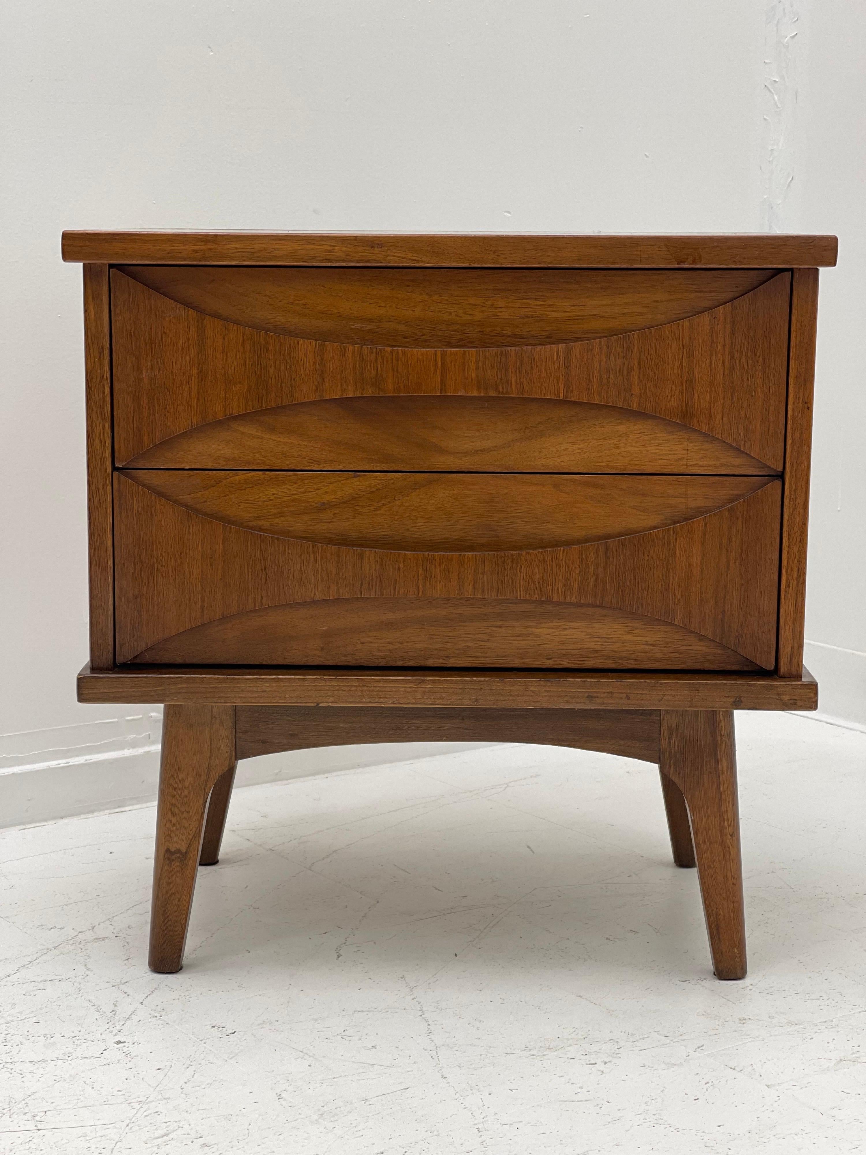 Unique mid-century night stand with walnut construction, including sculpted drawer fronts, tapered legs and plenty of stylish storage. 

Measures: 24 W, 16 D, 24.5 H.
