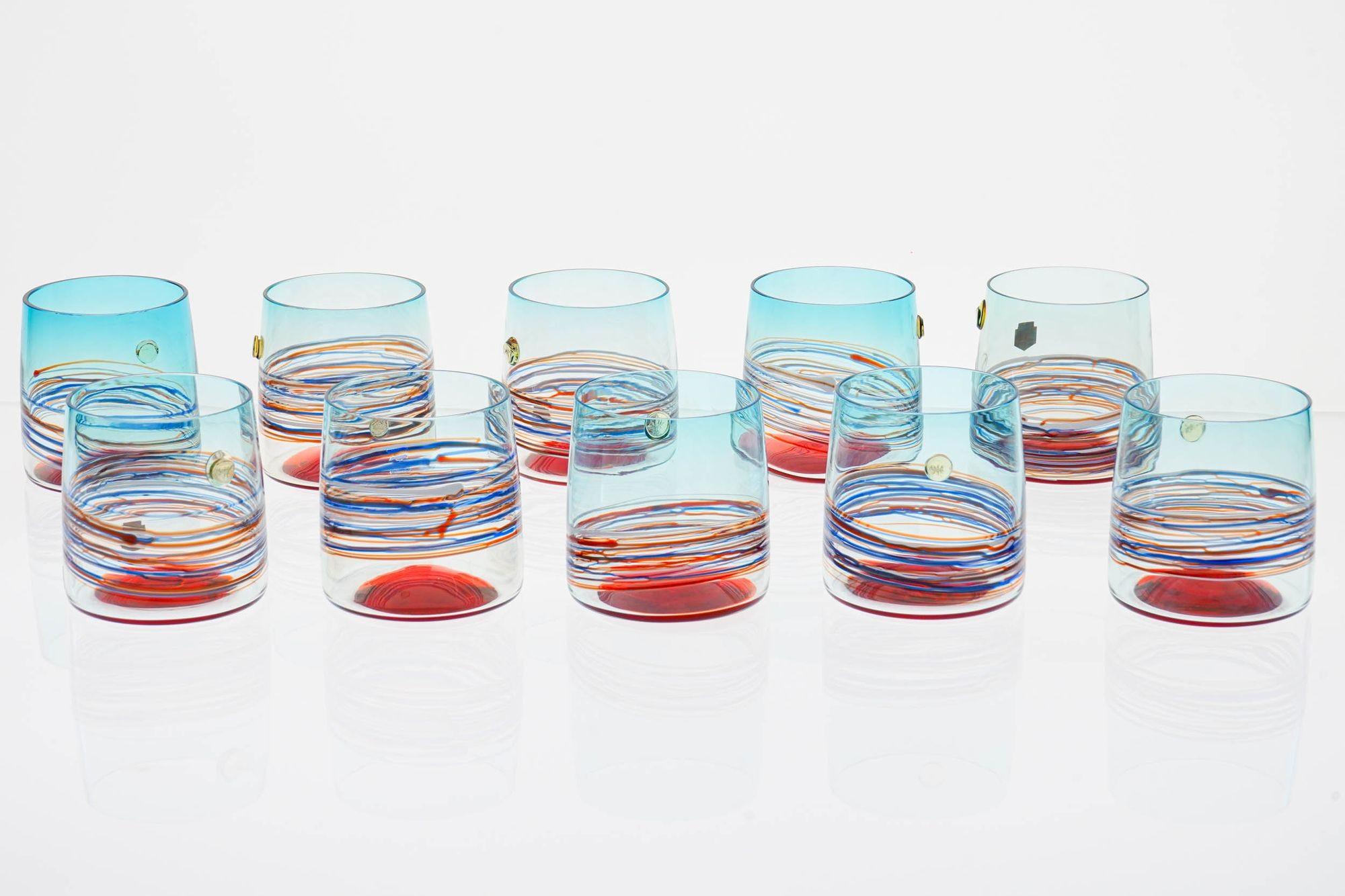 This set of 10 Cenedese cocktail/whisky glasses, meticulously crafted in the renowned Murano glass-making tradition, is a rare work of art.

These glasses showcase a remarkable array of glass-making techniques. From the ethereal Aquamarine Sfumato