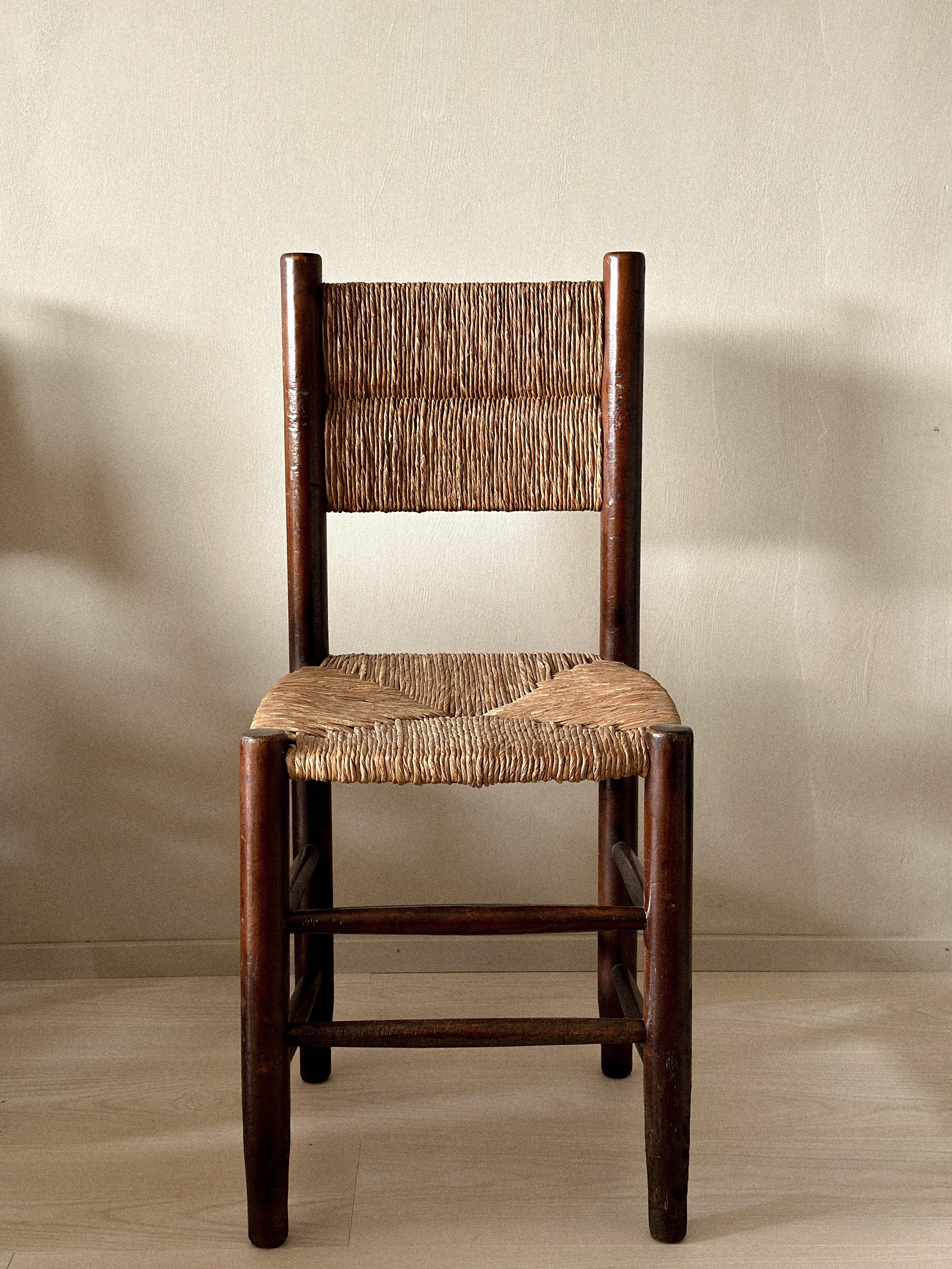 Ensemble de 12 chaises de salle à manger en jonc dans le style de Charlotte Perriand, France, c. 1960. Structure en bois massif avec assise et dossier en jonc tressé à la main.
Structure saine, usure et patine visibles. Quelques fissures et un éclat