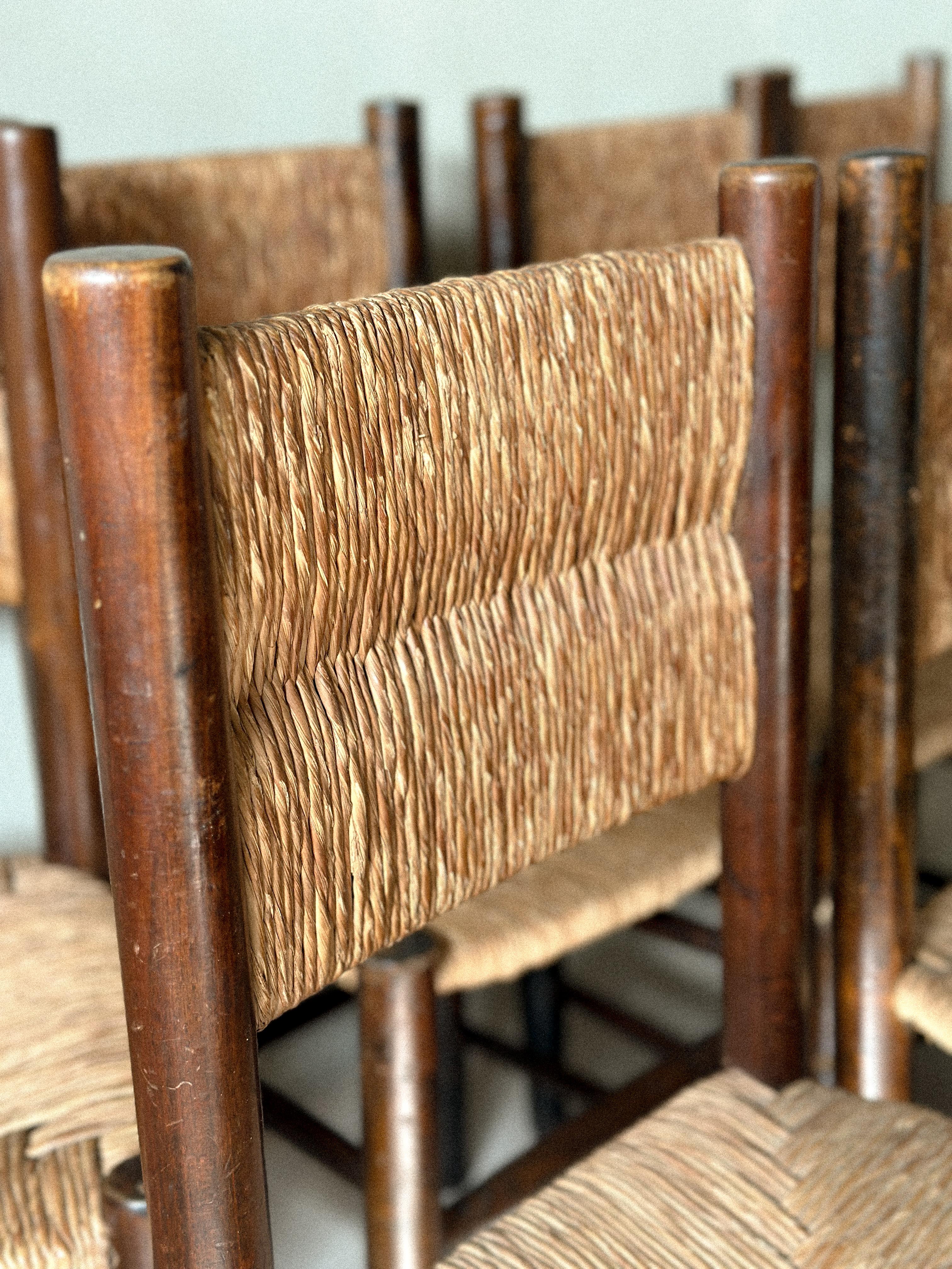 Paille Ensemble unique de 12 chaises de salle à manger en jonc dans le goût de Charlotte Perriand, France années 1960 en vente