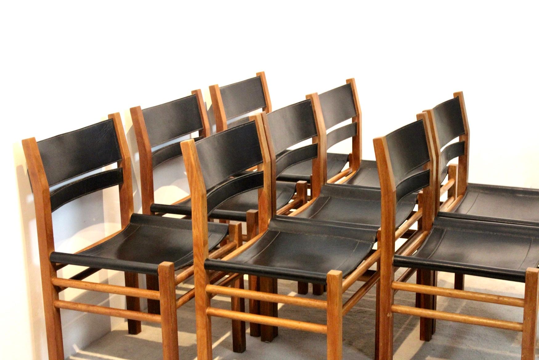 Set of 8 unique Scandinavian chairs. With a solid honey colored oak base and a strong black saddle leather seat and backrest. The chairs are completely made of wood with the use of unique craftsmanship without the use of screws. Very nice