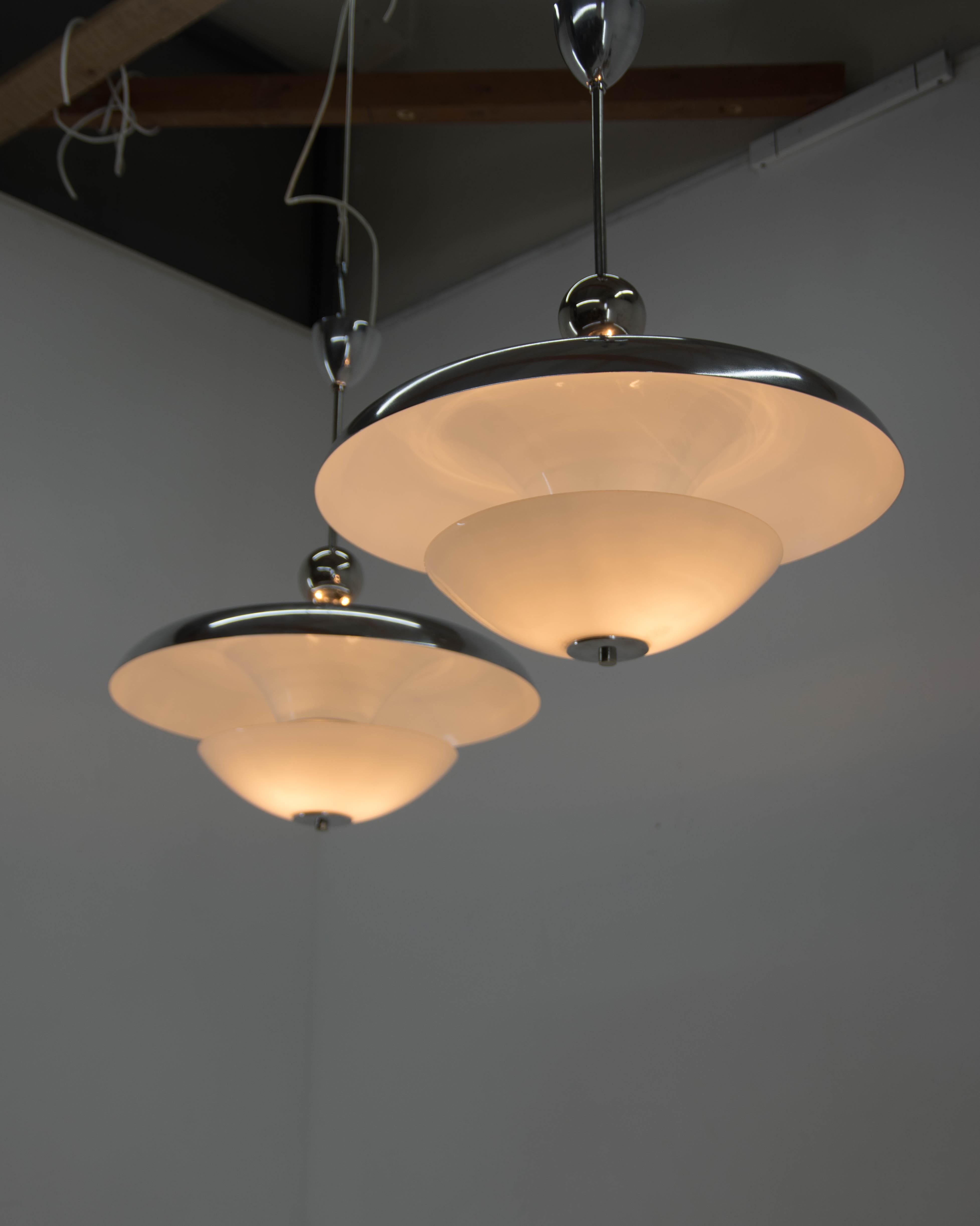 Set of two Bauhaus chandeliers designed and produced by Franta Anyz.
Professionally restored: polished, new white paint, rewired: two separate circuits - 3+2 E25-E27 bulbs
Opaline glass marked by CMS Triplex.
US wiring compatible.