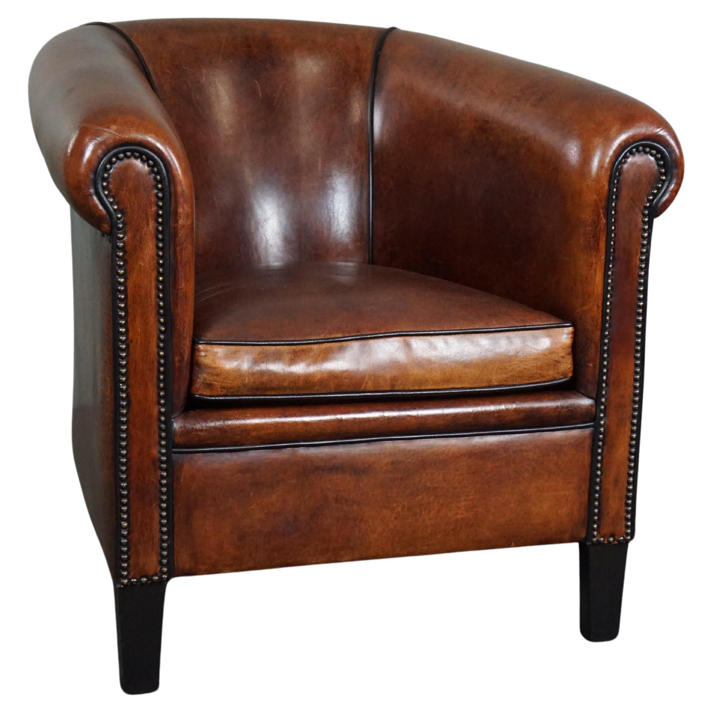 Unique sheep leather club chair with black piping and decorative nails For Sale