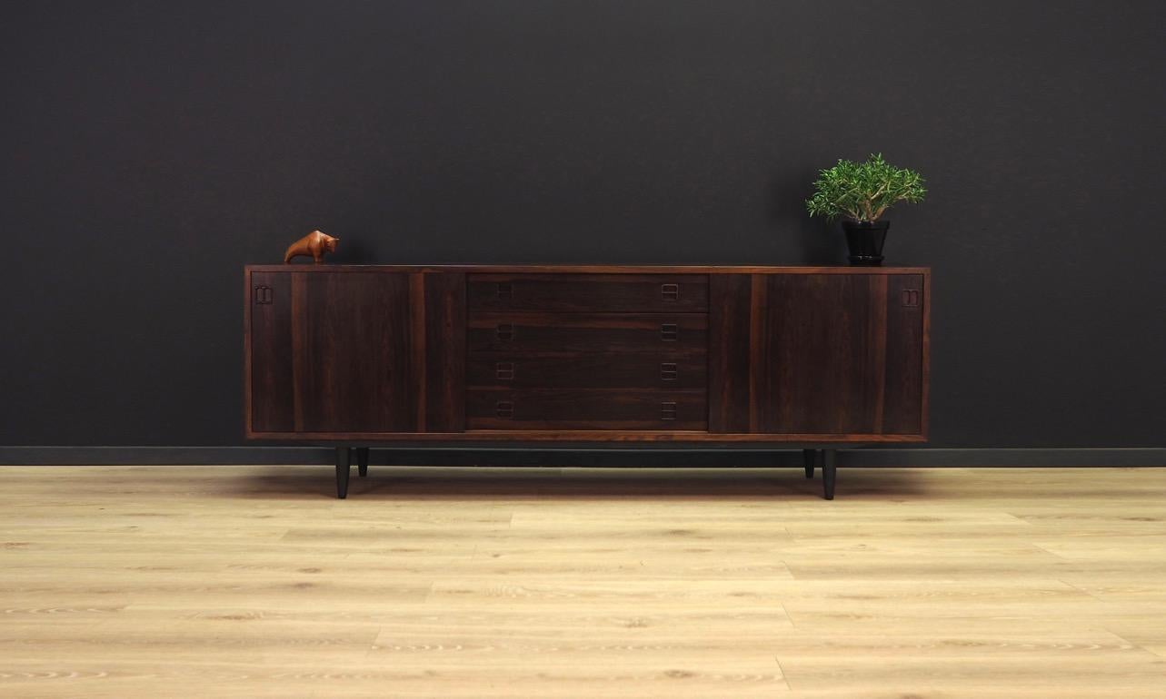 Brilliant sideboard from the 1960s-1970s, Minimalist form - Danish design. Surface finished with rosewood veneer. Spacious interior behind sliding doors, four drawers in the central section. Preserved in good condition (small bruises and scratches)