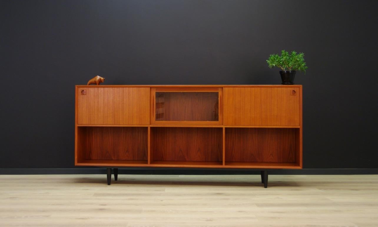 Unique sideboard on black legs from the 1960s-1970s, Scandinavian design, minimalist form. Behind the sliding door there is ample space with shelves. In the bottom section - shelf. The form is veneered with teak. The item is preserved in good