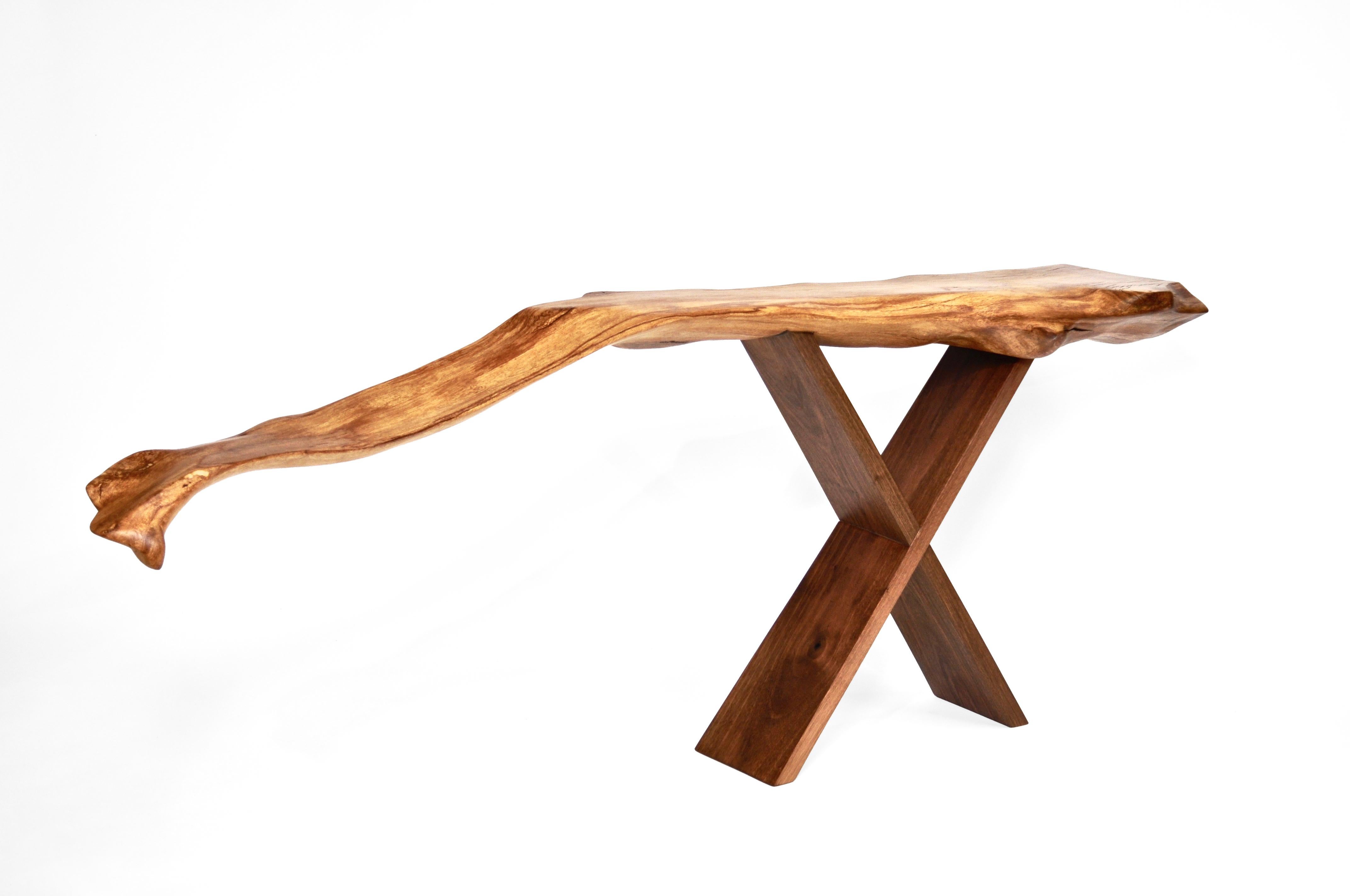 Unique signed console by Jörg Pietschmann
Console · Beech root, walnut 
H 75 X W 194 x D 34 cm
Curved piece of beech root on scissors stand of European walnut.
Polished oil finish.


In Pietschmann’s sculptures, trees that for centuries were