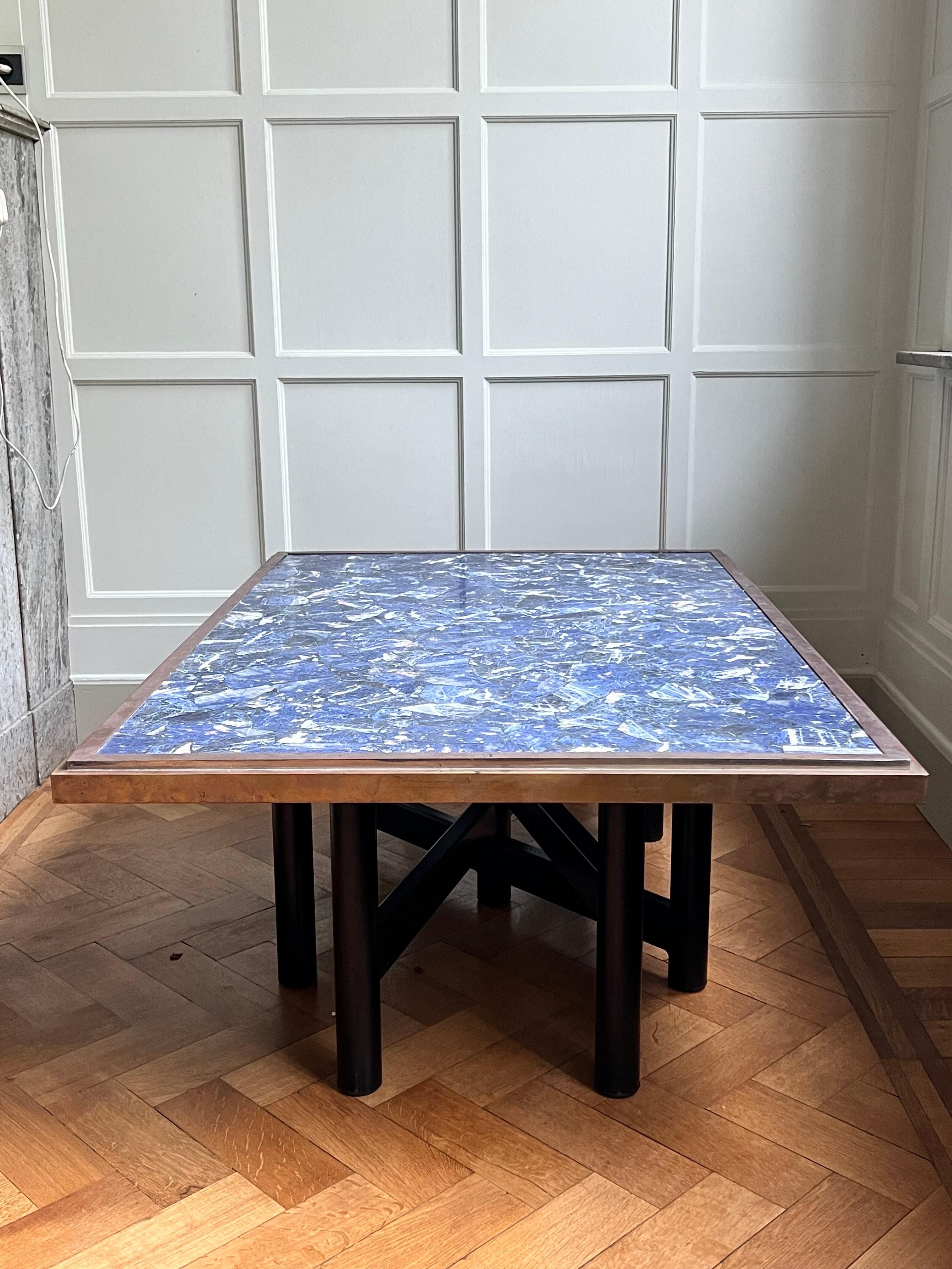 This is one of a kind sodalite stone table! The top is made out of stones with a brass frame to sublimely the top. The base is made out of black painted steel in a typical 1970's vibe used by decorators and architects in Belgium. It is in the vibe