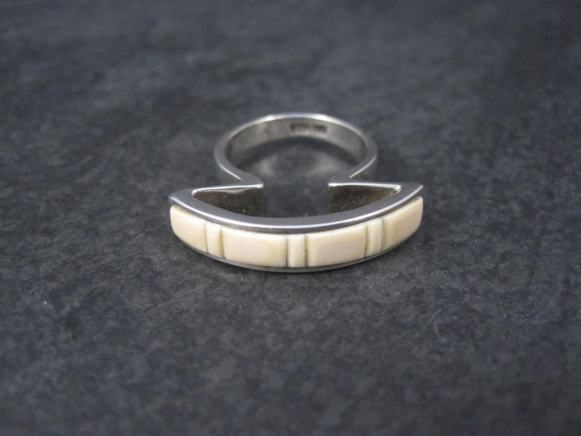 This gorgeous, one of a kind ring is sterling silver with coral inlay.
It is an older creation from artist Kelly Charveaux.

The face of this ring measures 1 1/16 inches north to south with a rise of 9mm off the finger.
Size: 6

Marks: