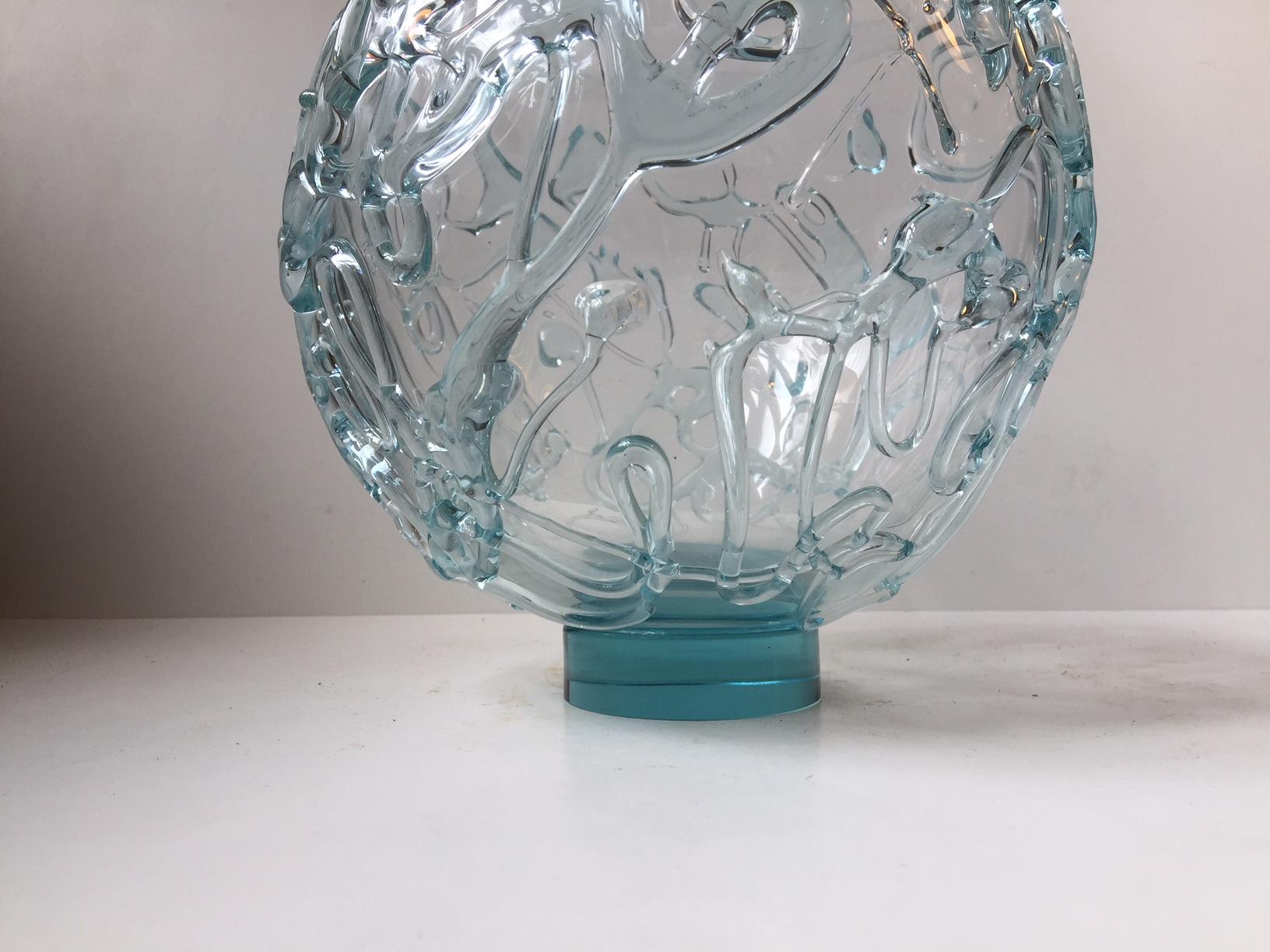 Large circular vase in light-blue toned clear art glass. Its an unique piece and its signed by the artist, numbered and dated. It is decorated with applied threads of glass creating an abstract motif around the entire perimeter of the vase. Some of