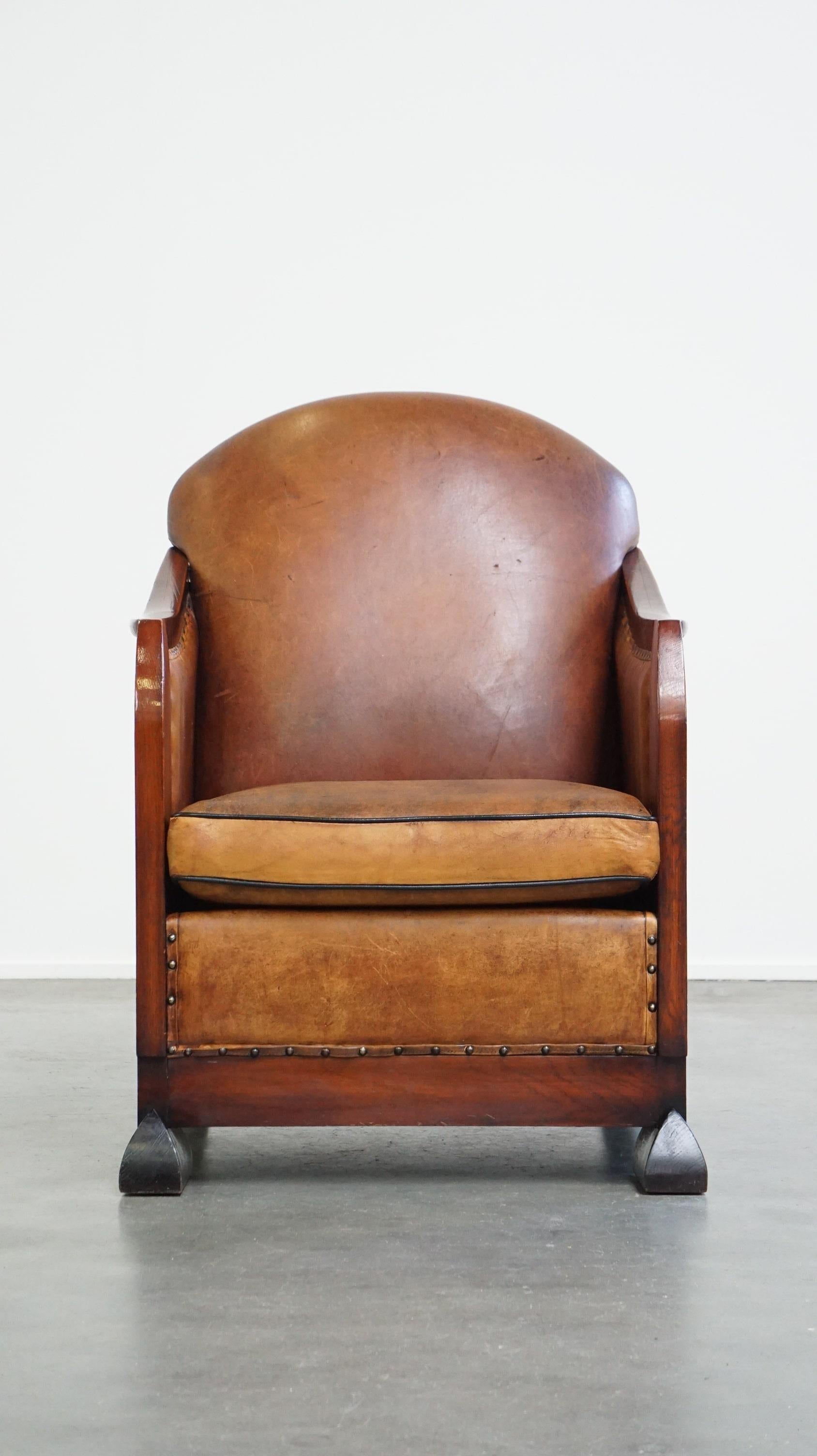Dieser Blickfang hat durch sein Design und seine Oberflächen ein einzigartiges, herrschaftliches Aussehen. Dieser Schafsfellsessel ist mit Holz kombiniert und mit dekorativen Nagelköpfen versehen. Er ist mit einem losen Sitzkissen ausgestattet und