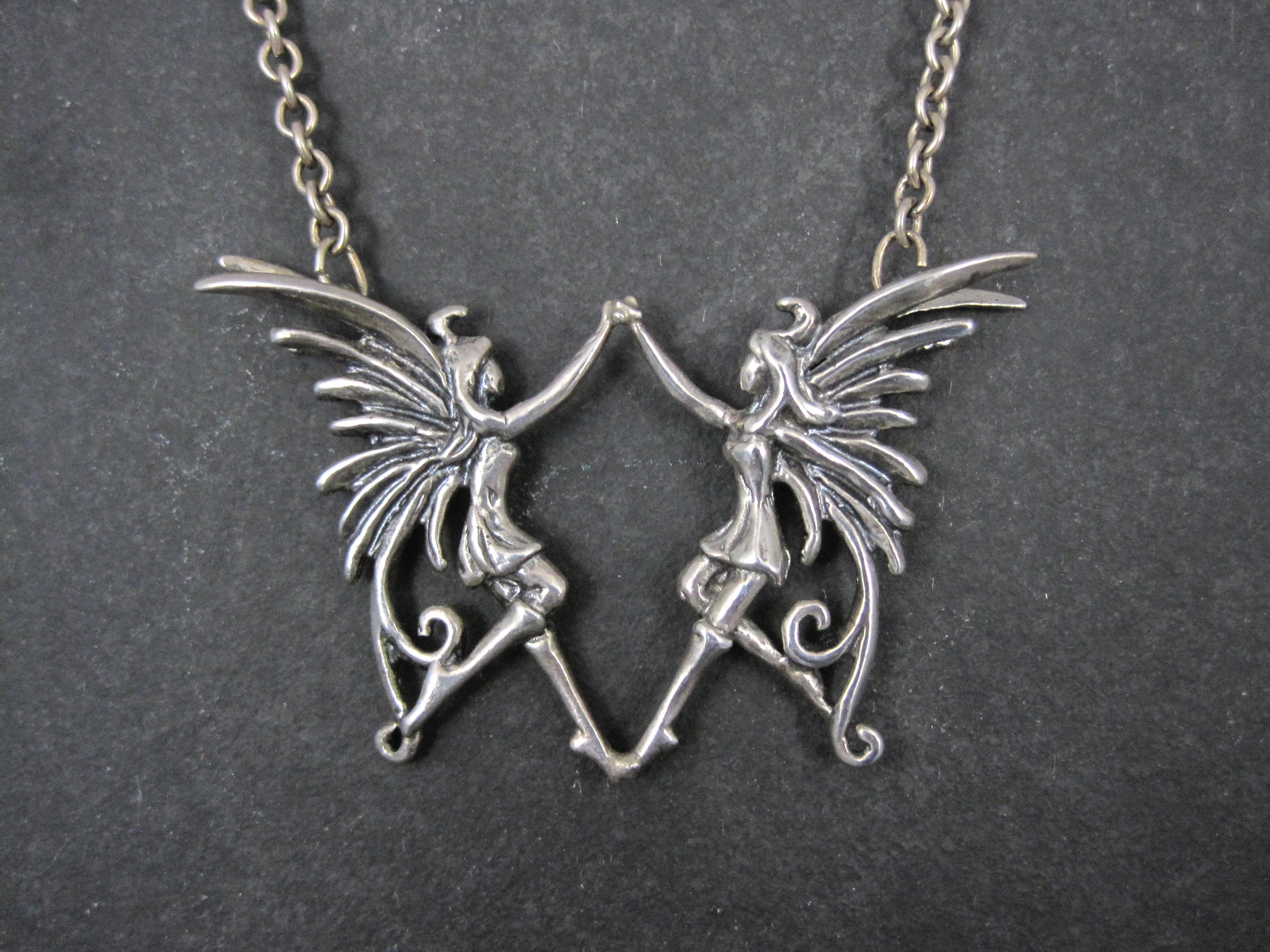 This beautiful and unusual necklace is sterling silver.
It features detailed fairies touching toes and holding hands as if they were dancing.

The pendant measures 1 5/8 by 2 9/16 inches.
The chain measures 17 1/2 inches from end to end.
Weight: